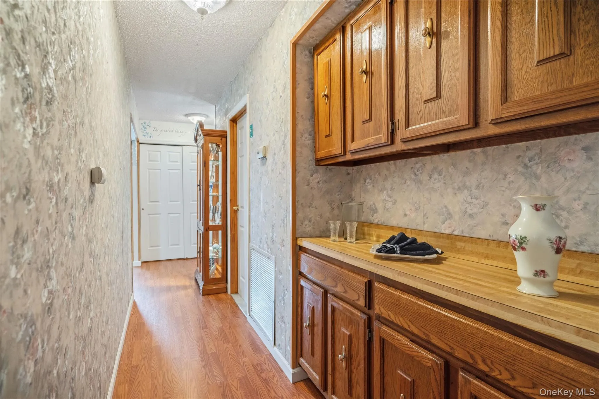 This hallway just off the kitchen, leads to the laundry & utility room, and down to the home's front entry way; but it is punctuated by this hallway butler's pantry with built in cabinetry & serving counter for additional storage & prep space for the kitchen & dining room. This hallway just off the kitchen, leads to the laundry & utility room, and down to the home's front entry way; but it is punctuated by this hallway butler's pantry with built in cabinetry & serving counter for additional storage & prep space for the kitchen & dining room.