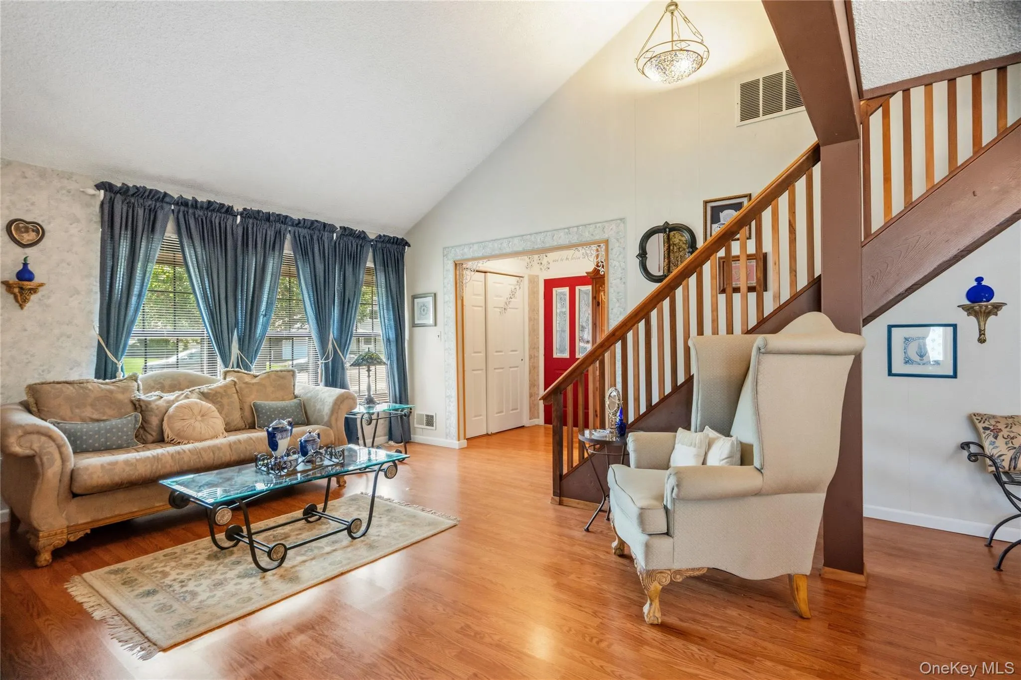 The view from the dining room back towards the living room and the entrance foyer with its large coat closet & red front door. The view from the dining room back towards the living room and the entrance foyer with its large coat closet & red front door.