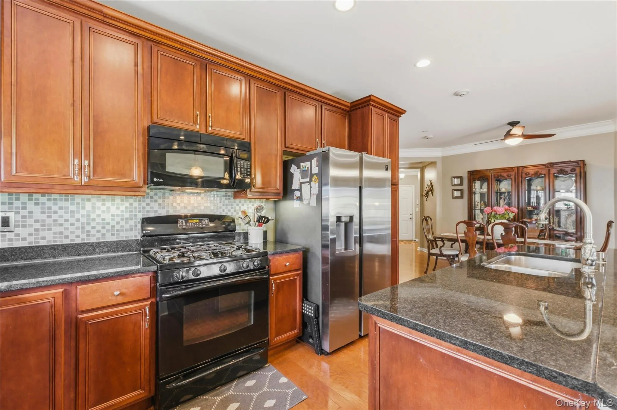 Perfectly suited for today's lifestyle, this open-concept kitchen anchors the home's single-level floor plan with granite countertops, updated stainless steel appliances, abundant cabinetry, and a center island. The seamless connection to the dining and living areas creates a bright, airy atmosphere ideal for both relaxed daily living and entertaining. Perfectly suited for today's lifestyle, this open-concept kitchen anchors the home's single-level floor plan with granite countertops, updated stainless steel appliances, abundant cabinetry, and a center island. The seamless connection to the dining and living areas creates a bright, airy atmosphere ideal for both relaxed daily living and entertaining.