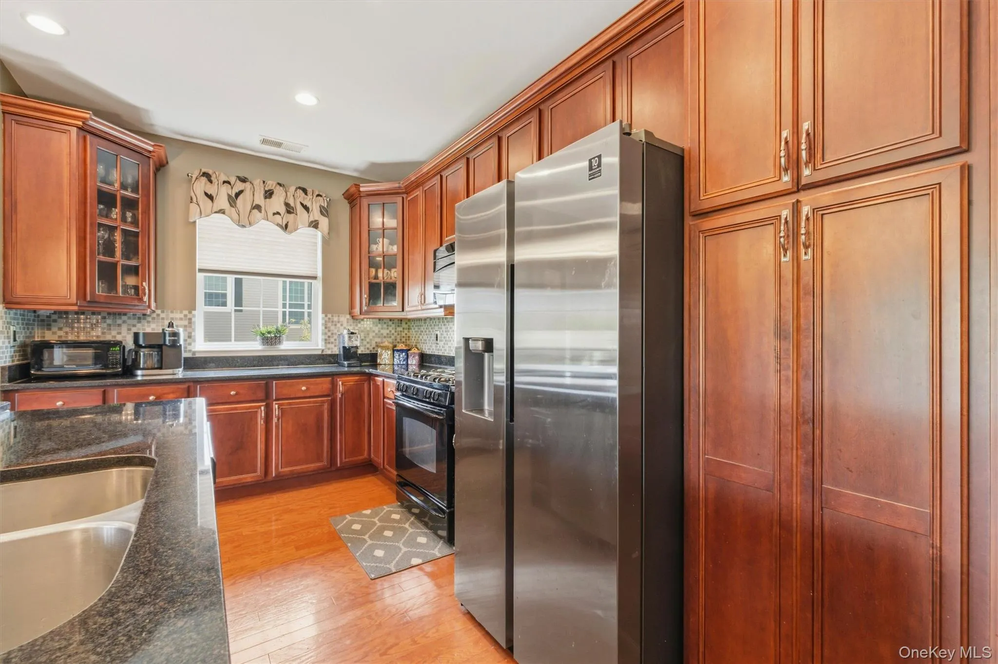 The heart of the home, this beautifully appointed kitchen features rich wood cabinetry, granite countertops, updated stainless steel appliances, and abundant storage. Designed for both everyday living and entertaining, the functional layout offers generous workspace, a sunny dining area, and seamless flow to the adjoining living and dining spaces, making it the perfect gathering place for family and friends. The heart of the home, this beautifully appointed kitchen features rich wood cabinetry, granite countertops, updated stainless steel appliances, and abundant storage. Designed for both everyday living and entertaining, the functional layout offers generous workspace, a sunny dining area, and seamless flow to the adjoining living and dining spaces, making it the perfect gathering place for family and friends.