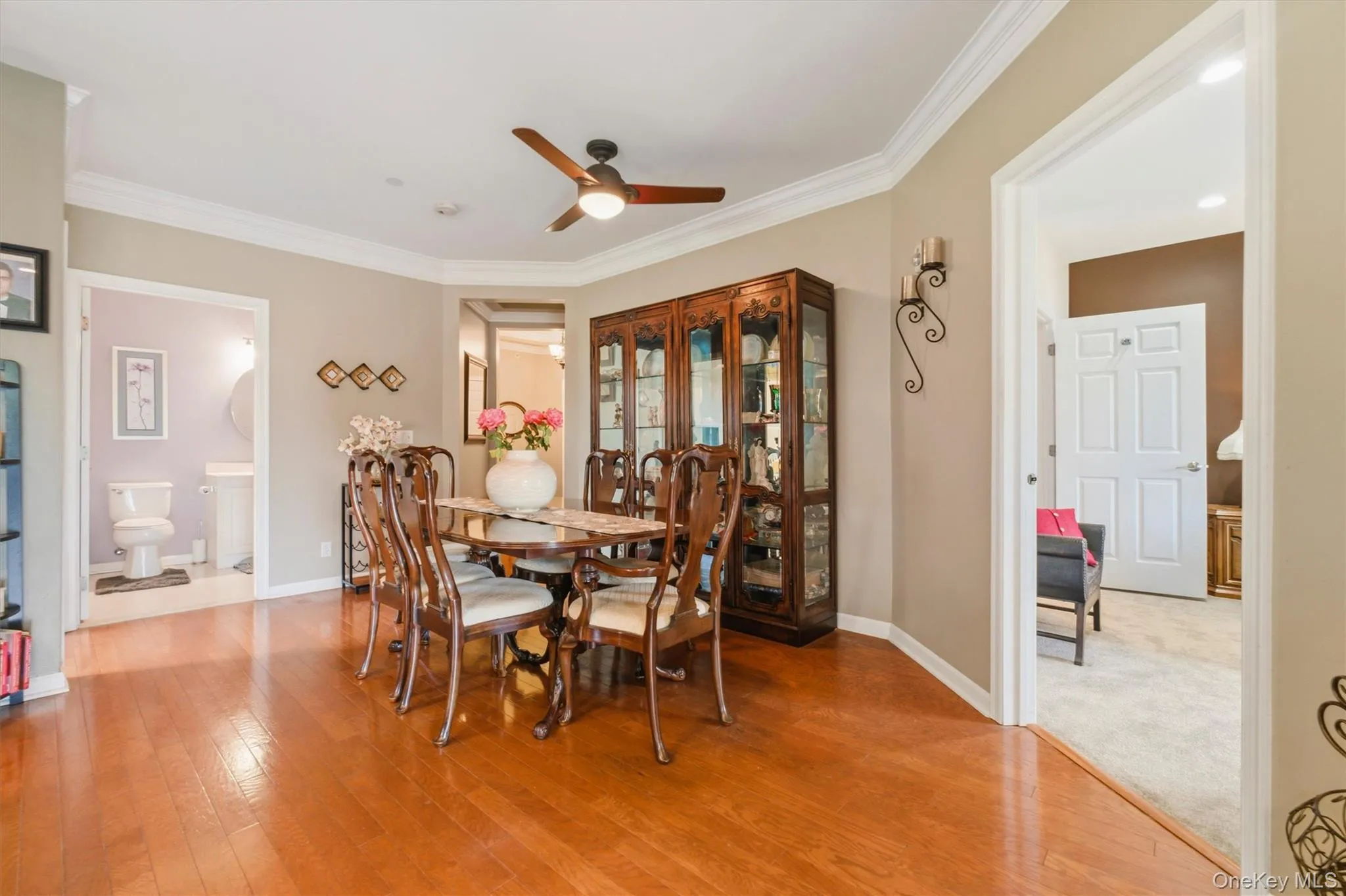 The spacious formal dining area is beautifully defined by an elegant fan and the continuation of gleaming hardwood floors, creating a cohesive and refined look. Perfectly positioned within the home’s open-concept layout, the dining space flows effortlessly into both the living area and kitchen, making it ideal for entertaining. The spacious formal dining area is beautifully defined by an elegant fan and the continuation of gleaming hardwood floors, creating a cohesive and refined look. Perfectly positioned within the home’s open-concept layout, the dining space flows effortlessly into both the living area and kitchen, making it ideal for entertaining.