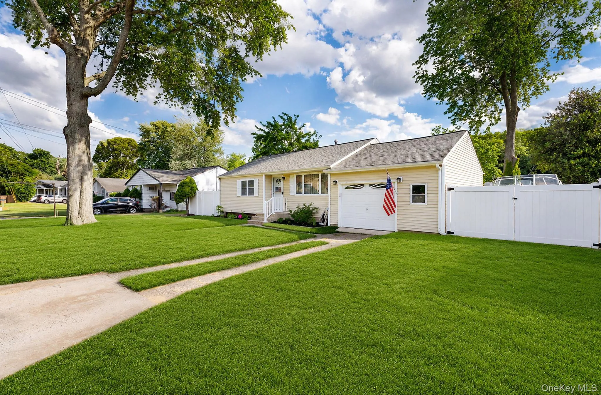 Exterior featuring light-colored siding, an attached garage, and a gabled roofline Exterior featuring light-colored siding, an attached garage, and a gabled roofline