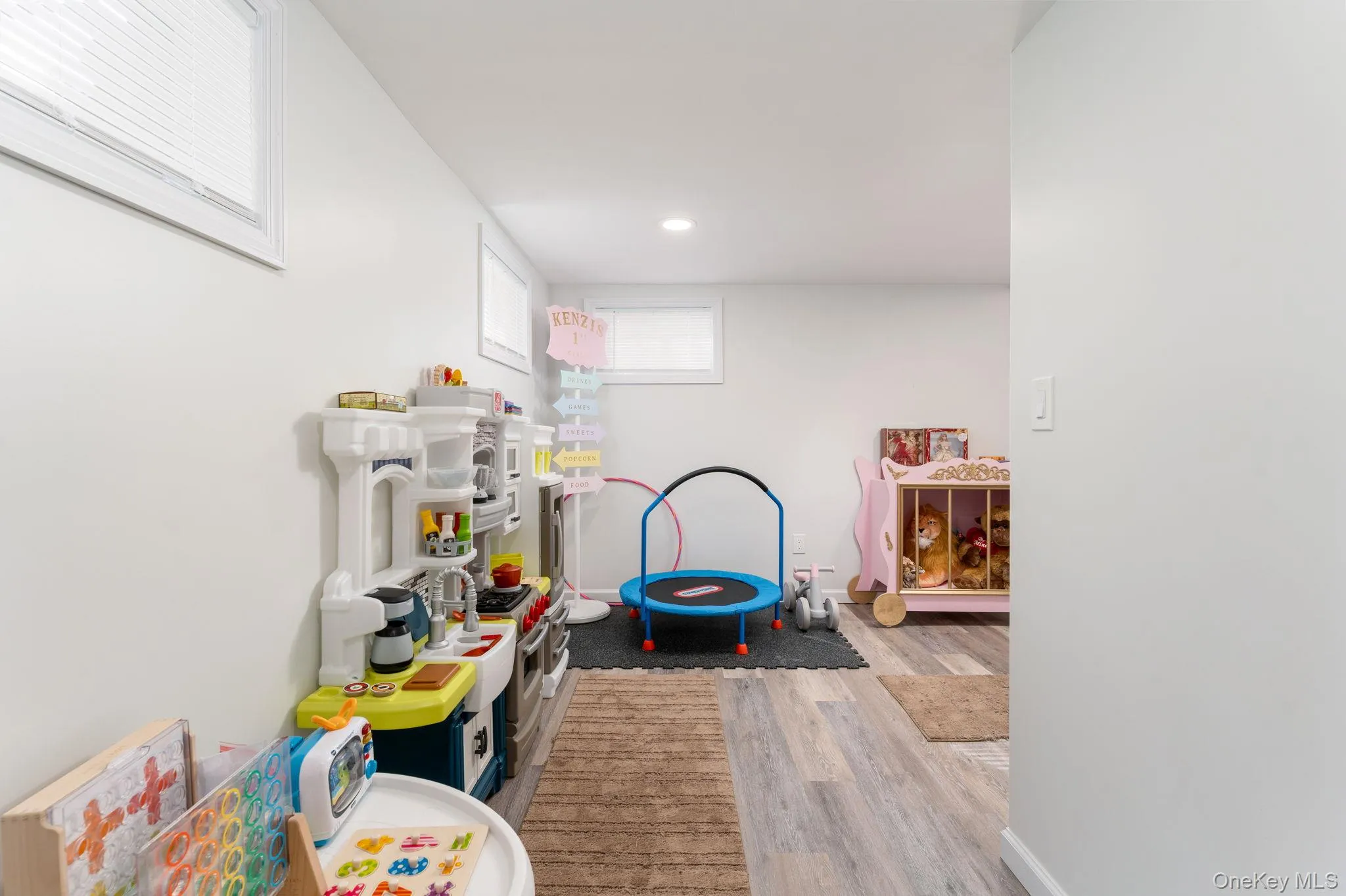 Interior space featuring light gray walls, recessed lighting, and wood-finish flooring Interior space featuring light gray walls, recessed lighting, and wood-finish flooring