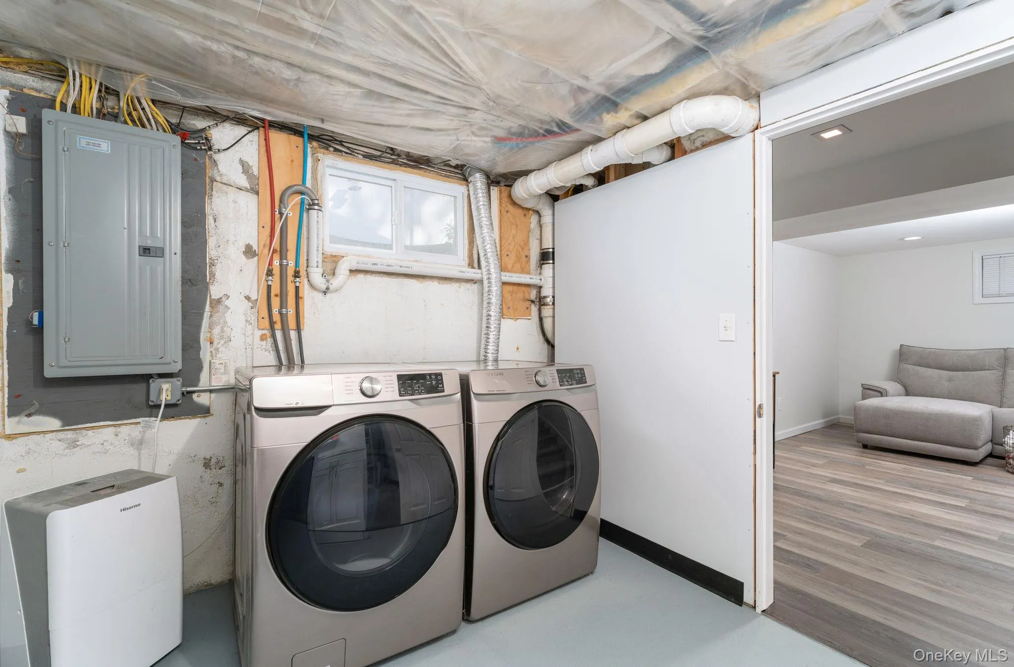 Dedicated laundry area featuring a window, electrical panel, and utility connections. Dedicated laundry area featuring a window, electrical panel, and utility connections.