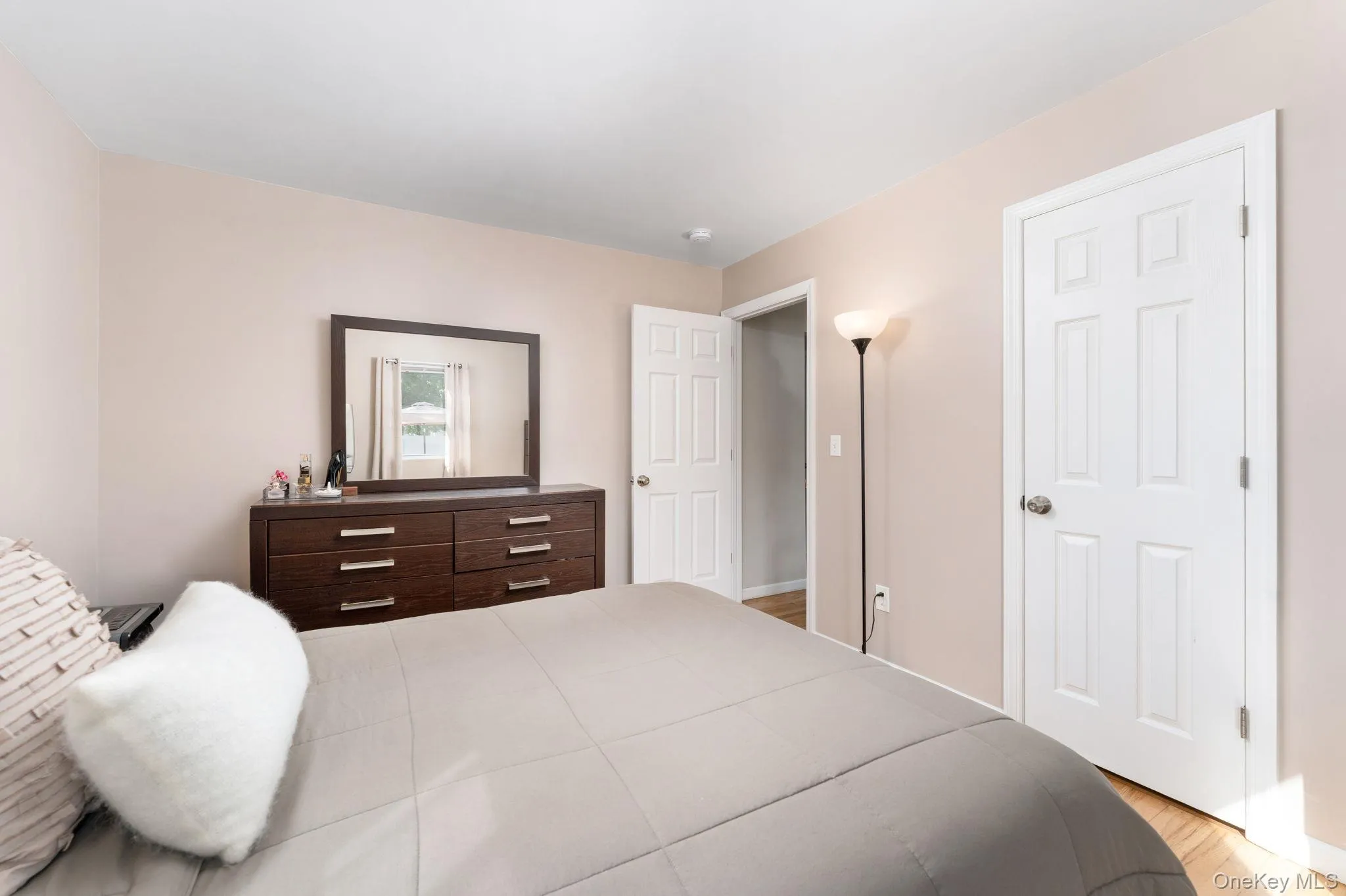 Primary Bedroom with Neutral-toned walls complement hardwood flooring Primary Bedroom with Neutral-toned walls complement hardwood flooring