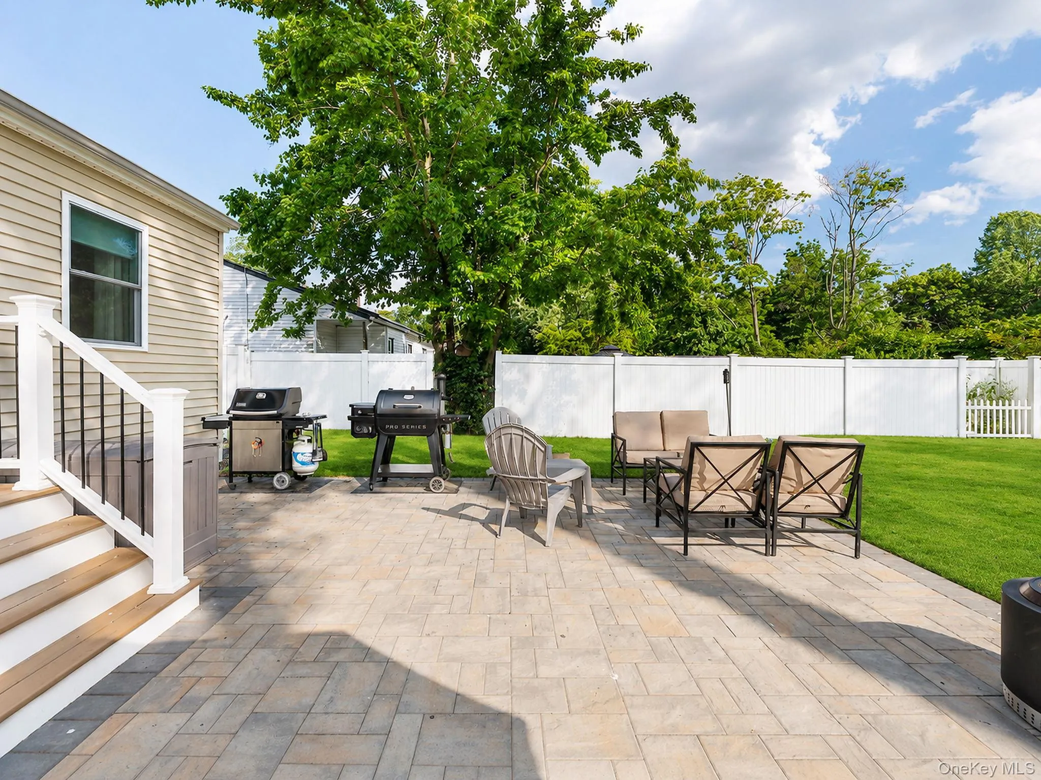 Expansive paver patio with direct access to a well manicured lawn Expansive paver patio with direct access to a well manicured lawn