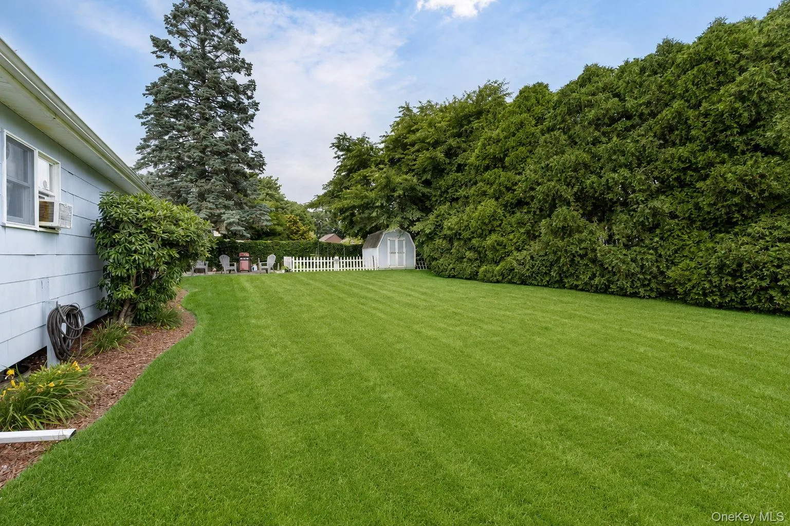 Expansive lawn area featuring a decorative white picket fence Expansive lawn area featuring a decorative white picket fence