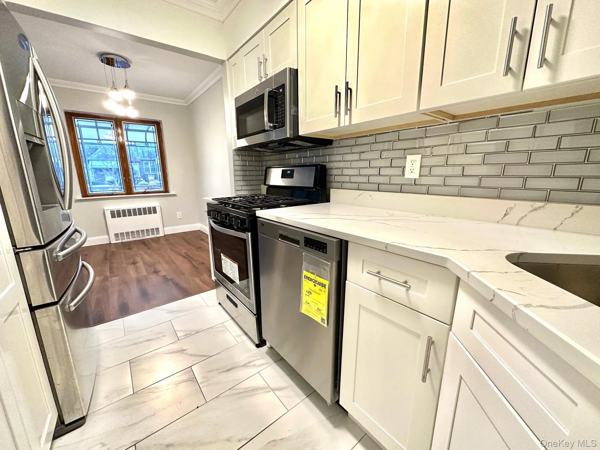 Modern kitchen featuring white shaker cabinetry, stainless steel appliances, and sleek quartz countertops Modern kitchen featuring white shaker cabinetry, stainless steel appliances, and sleek quartz countertops