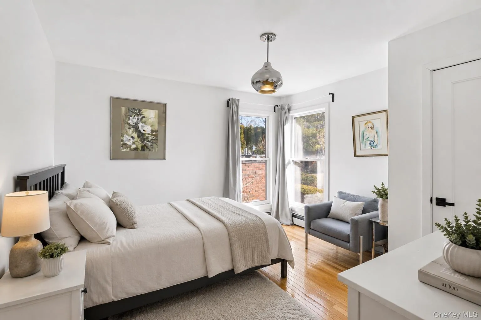 Hardwood flooring throughout featuring white walls and a pendant light fixture Hardwood flooring throughout featuring white walls and a pendant light fixture