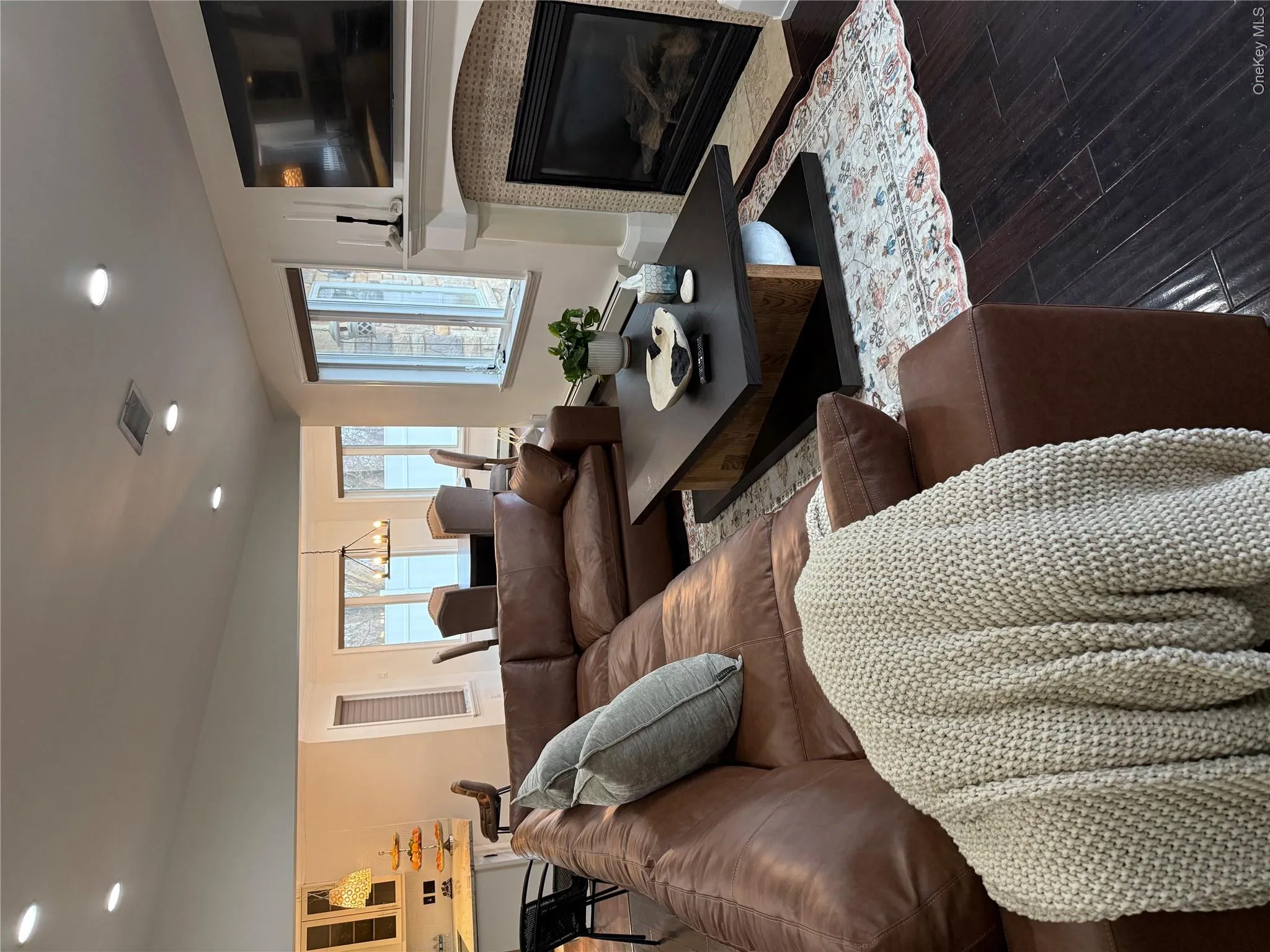 Living area featuring visible vents, wood finished floors, recessed lighting, a fireplace, and lofted ceiling Living area featuring visible vents, wood finished floors, recessed lighting, a fireplace, and lofted ceiling