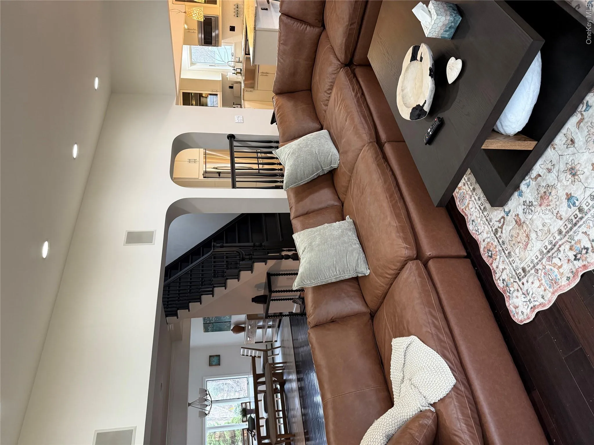 Living room featuring wood finished floors, plenty of natural light, recessed lighting, arched walkways, and stairs Living room featuring wood finished floors, plenty of natural light, recessed lighting, arched walkways, and stairs
