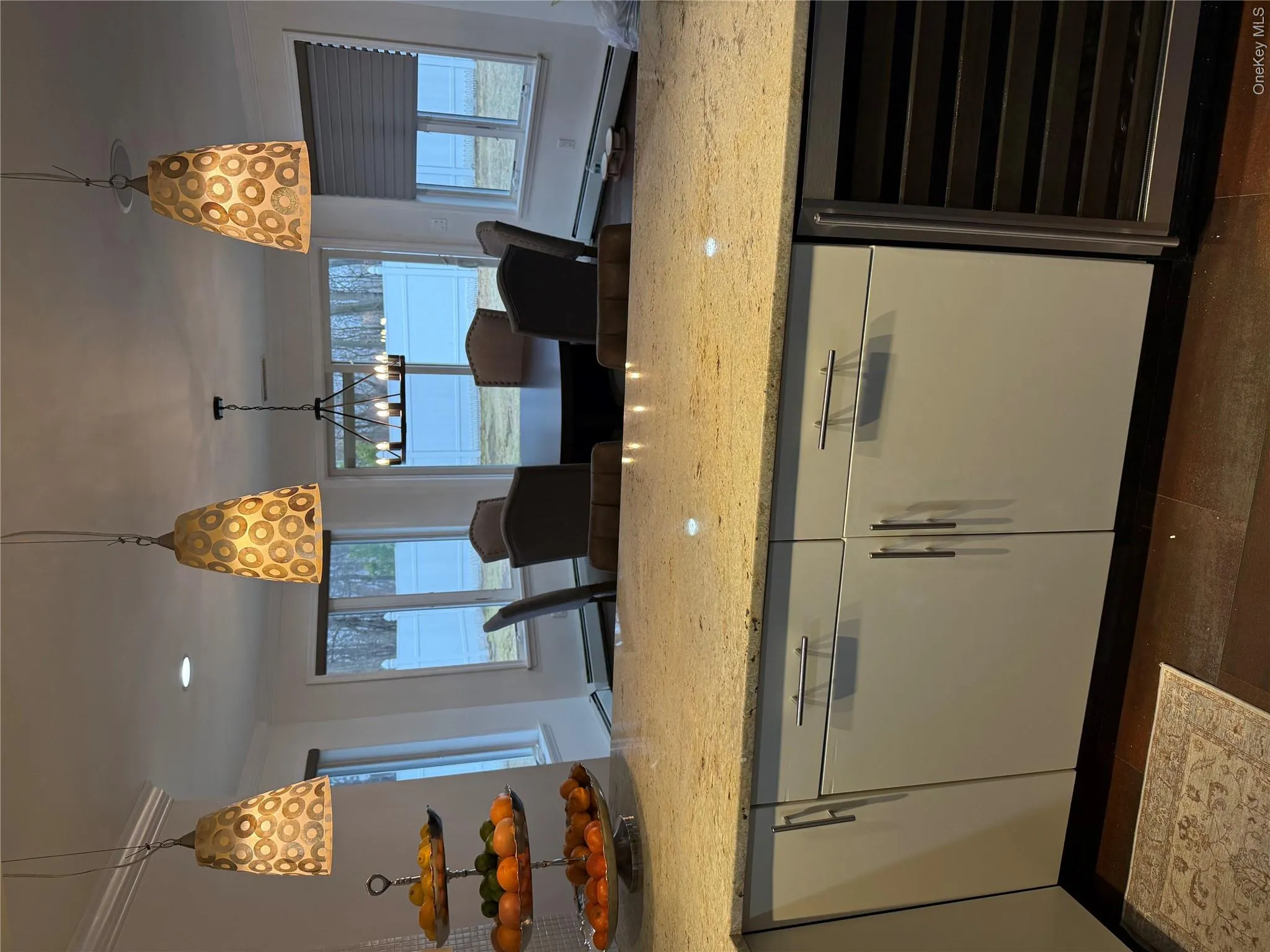 Kitchen with wine cooler, white cabinets, pendant lighting, and light stone countertops Kitchen with wine cooler, white cabinets, pendant lighting, and light stone countertops