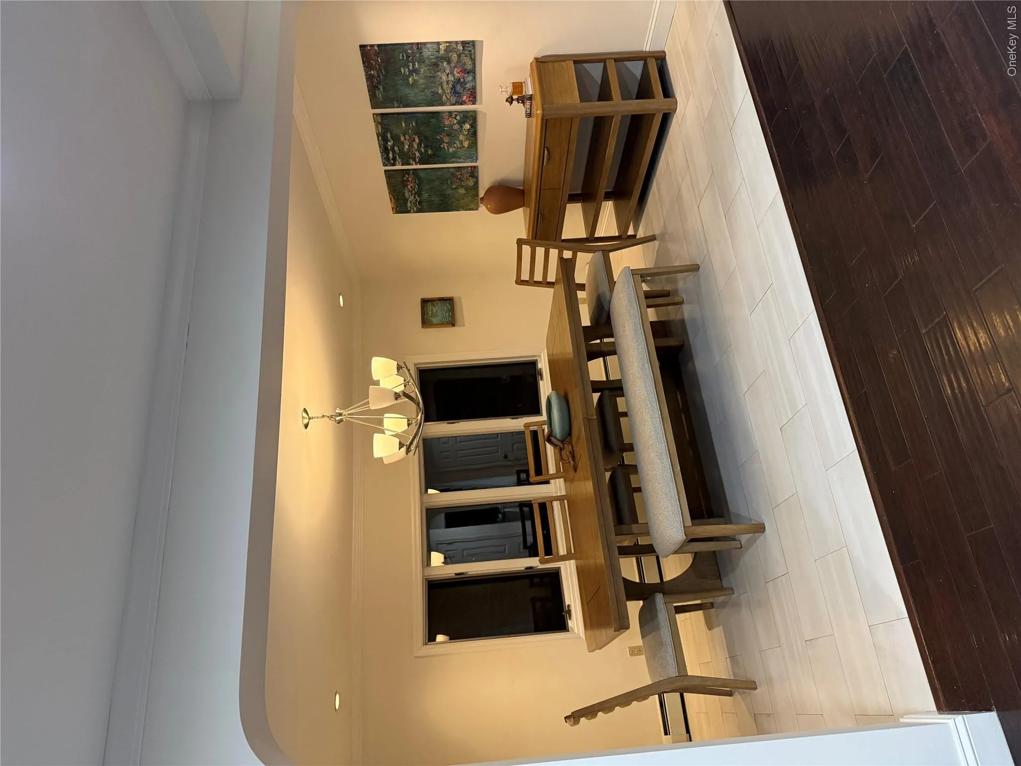 Dining room with a notable chandelier, ornamental molding, arched walkways, light wood finished floors, and baseboards Dining room with a notable chandelier, ornamental molding, arched walkways, light wood finished floors, and baseboards