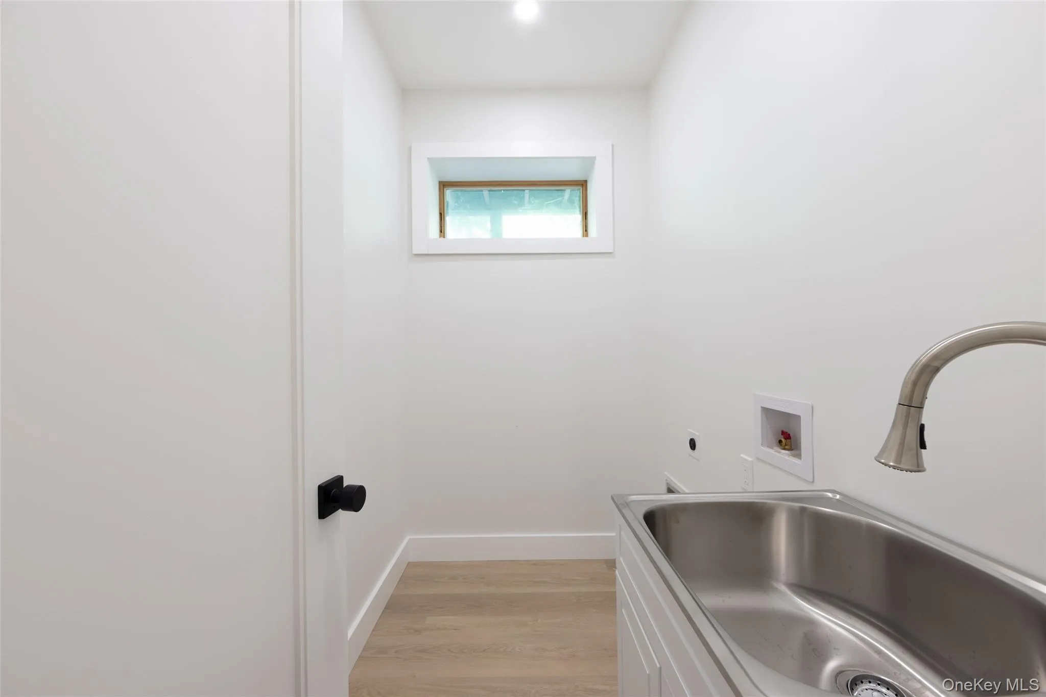 Utility sink with brushed nickel faucet, light wood-finish flooring, white cabinetry, and recessed lighting, washer and dryer hook up Utility sink with brushed nickel faucet, light wood-finish flooring, white cabinetry, and recessed lighting, washer and dryer hook up