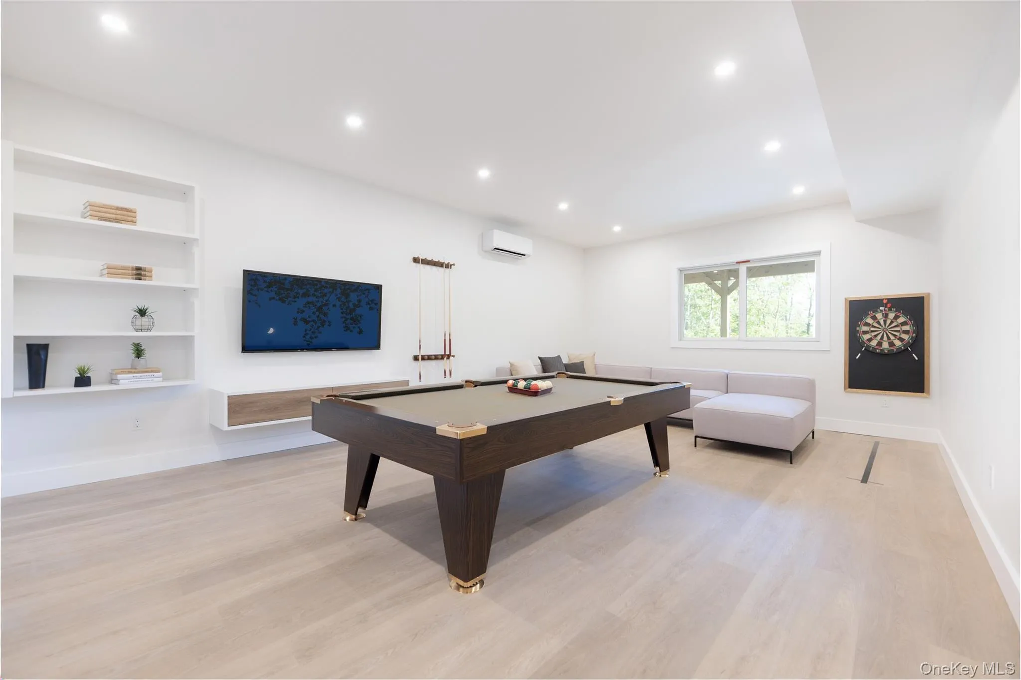 Spacious recreation area featuring light wood-finish flooring, recessed lighting, and built-in shelvingImages have been virtually staged to illustrate the property's potential Spacious recreation area featuring light wood-finish flooring, recessed lighting, and built-in shelvingImages have been virtually staged to illustrate the property's potential