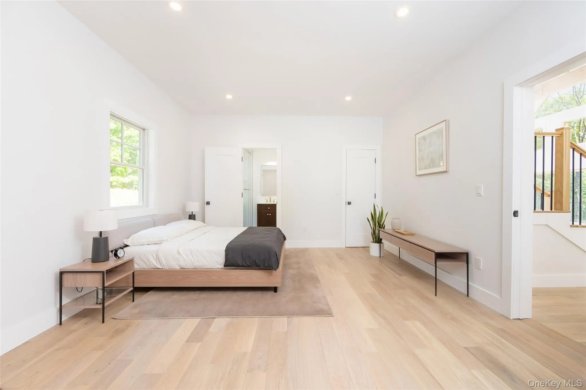 Bright bedroom featuring light wood-finish flooring, recessed lighting, and a window with exterior viewsImages have been virtually staged to illustrate the property's potential Bright bedroom featuring light wood-finish flooring, recessed lighting, and a window with exterior viewsImages have been virtually staged to illustrate the property's potential