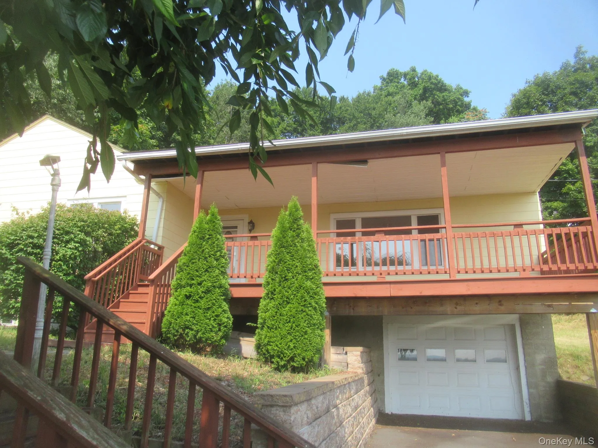 Back of house featuring an attached garage, stairs, and a porch Back of house featuring an attached garage, stairs, and a porch