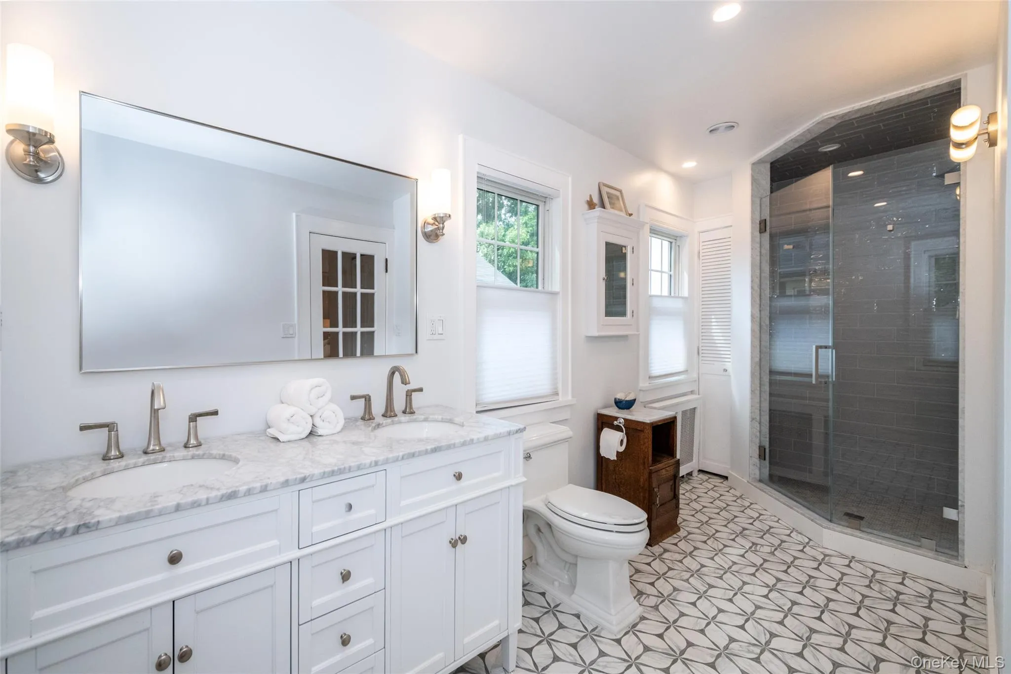 Primary bath features double-vanity sinks, gorgeous new tiling and glass shower Primary bath features double-vanity sinks, gorgeous new tiling and glass shower