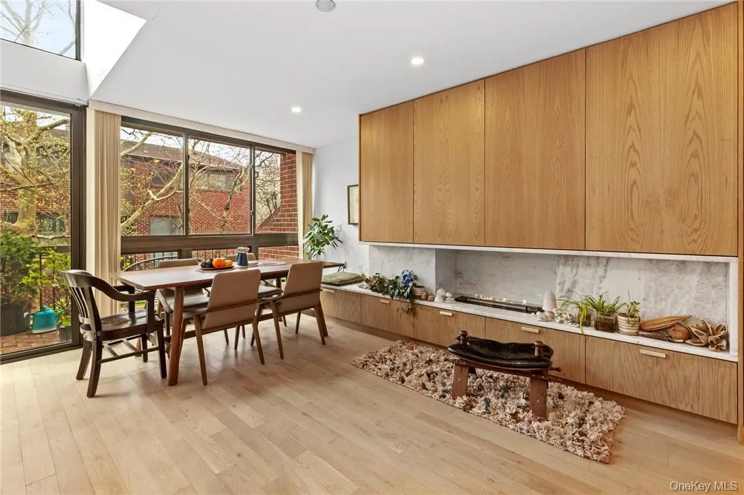Elegant dining area with large windows and a cozy fireplace, creating an inviting atmosphere for meals and gatherings. Elegant dining area with large windows and a cozy fireplace, creating an inviting atmosphere for meals and gatherings.