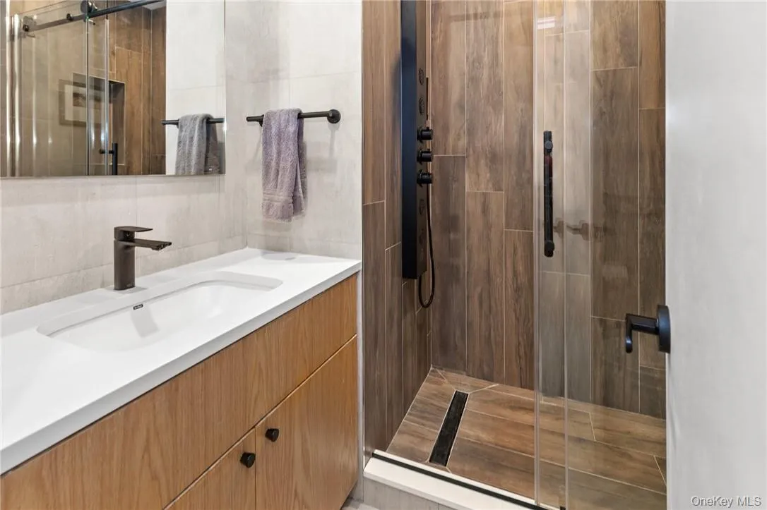 Modern upstairs full hall bath featuring a sleek vanity, spacious walk-in shower, and contemporary fixtures for a stylish and functional space. Modern upstairs full hall bath featuring a sleek vanity, spacious walk-in shower, and contemporary fixtures for a stylish and functional space.