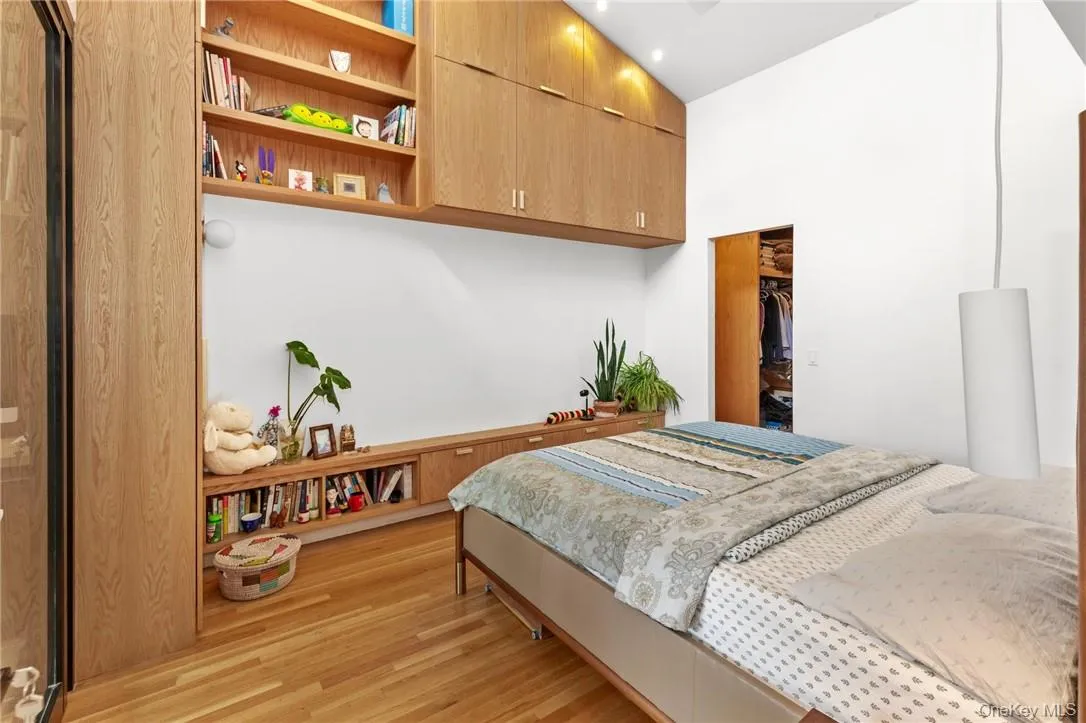 Inviting primary bedroom with abundant storage, built-in bookshelves, and a spacious walk-in closet, creating a cozy yet functional retreat. Inviting primary bedroom with abundant storage, built-in bookshelves, and a spacious walk-in closet, creating a cozy yet functional retreat.