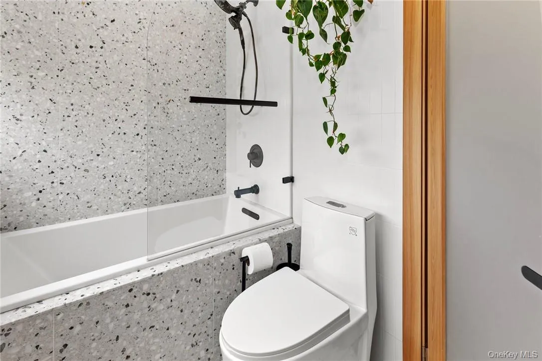 Luxurious primary suite bathroom with modern terrazzo tiles, sleek fixtures, and a spacious bathtub for ultimate relaxation. Luxurious primary suite bathroom with modern terrazzo tiles, sleek fixtures, and a spacious bathtub for ultimate relaxation.