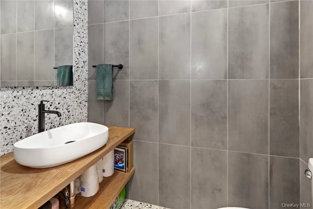 Elegant powder room with contemporary fixtures, sleek tile design, and a stylish vessel sink, perfect for guests. Elegant powder room with contemporary fixtures, sleek tile design, and a stylish vessel sink, perfect for guests.