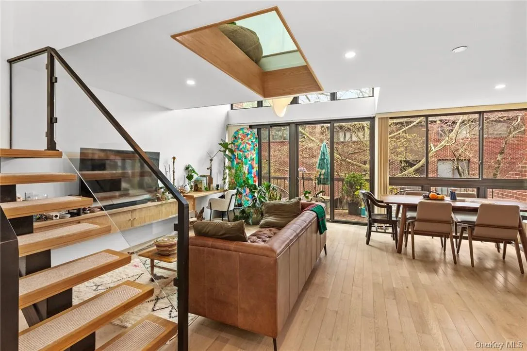 Stylish living room featuring a modern floating staircase, sleek TV setup, and abundant natural light. Stylish living room featuring a modern floating staircase, sleek TV setup, and abundant natural light.