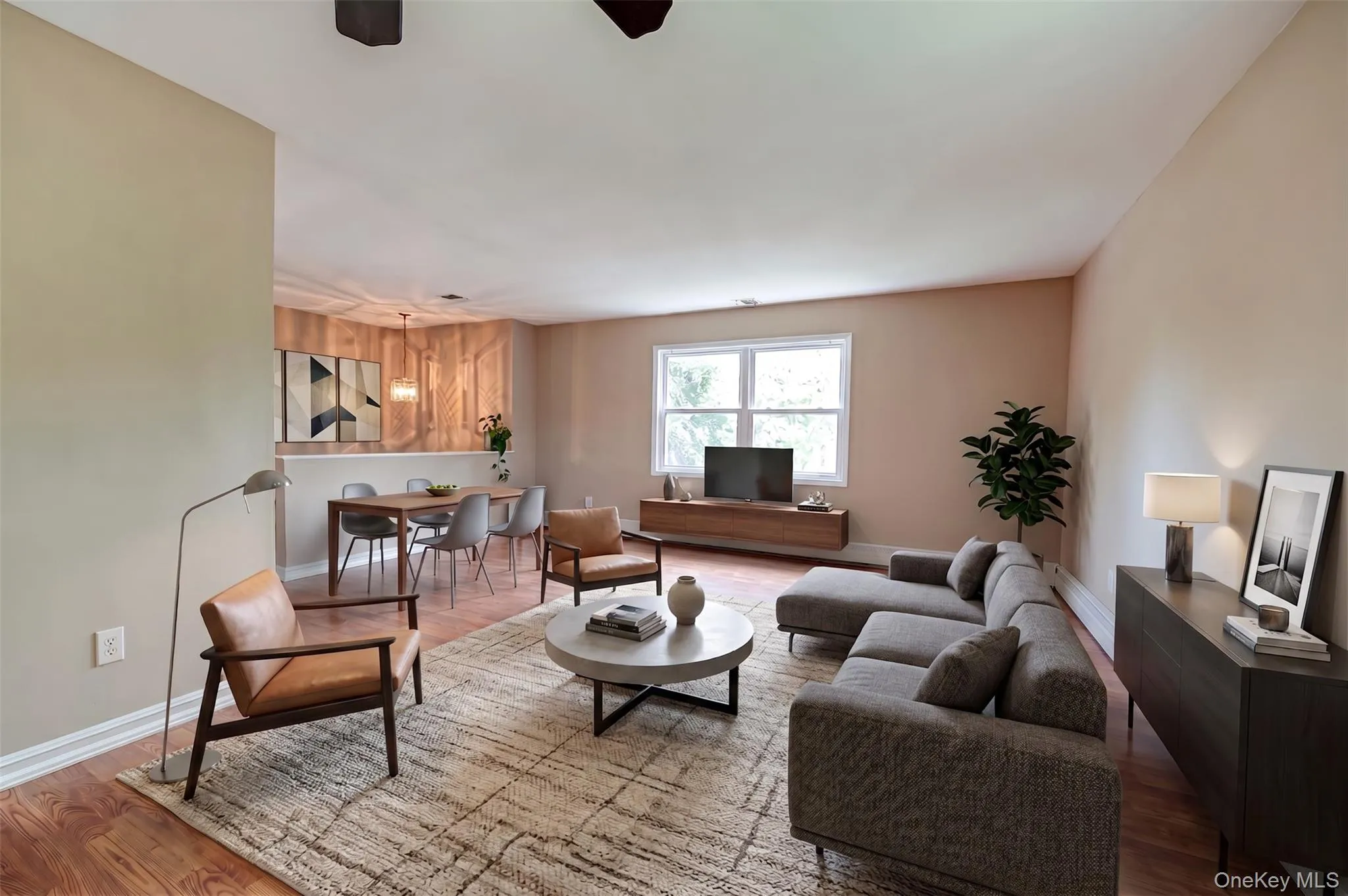 Open concept living area featuring wood-finish flooring, neutral wall tones, and recessed lighting Open concept living area featuring wood-finish flooring, neutral wall tones, and recessed lighting