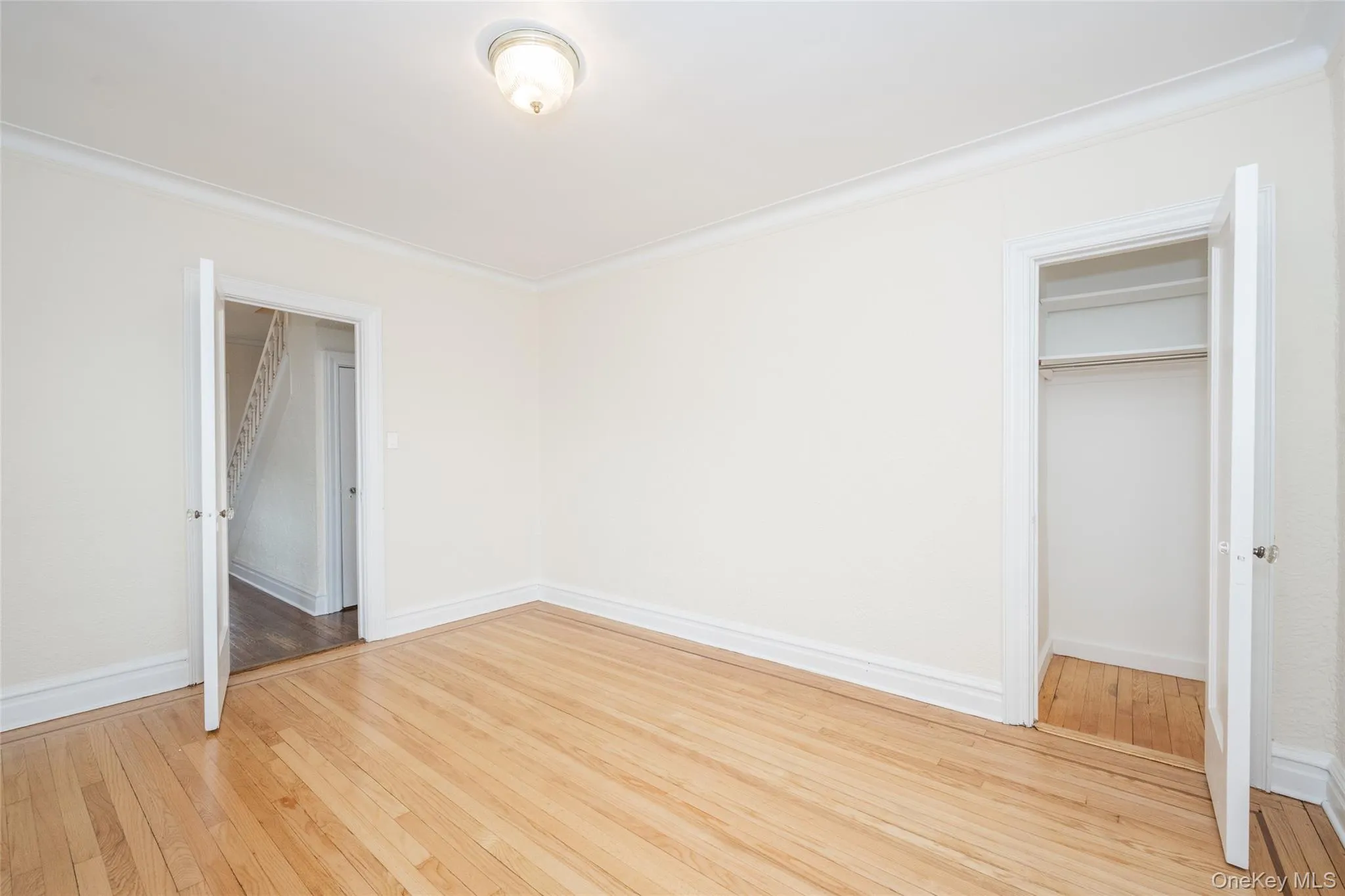 Bedroom 3 with Hardwood flooring throughout, white baseboards, and crown molding looks south and west. Bedroom 3 with Hardwood flooring throughout, white baseboards, and crown molding looks south and west.