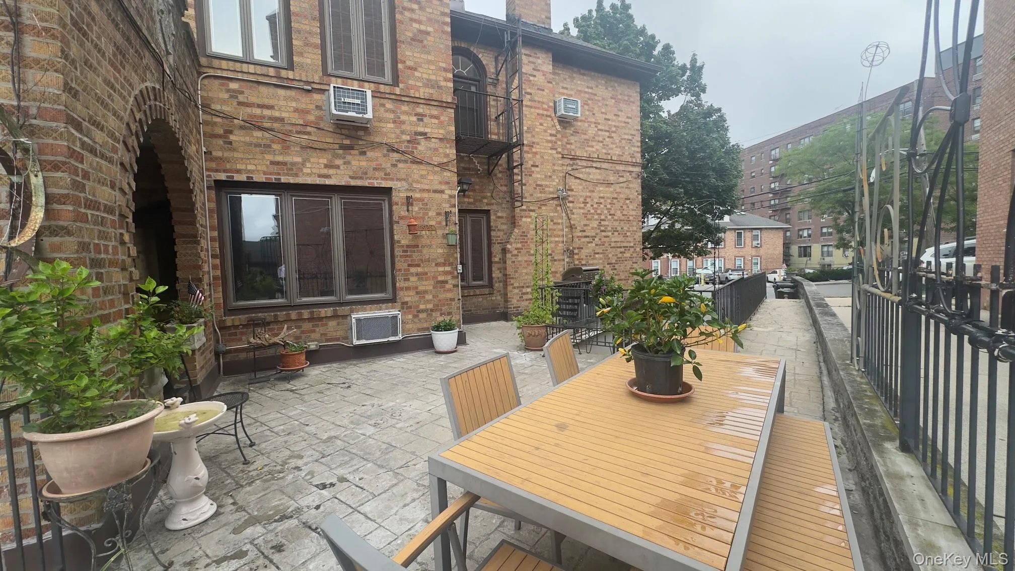 Paved patio area featuring a brick facade with arched architectural elements Paved patio area featuring a brick facade with arched architectural elements