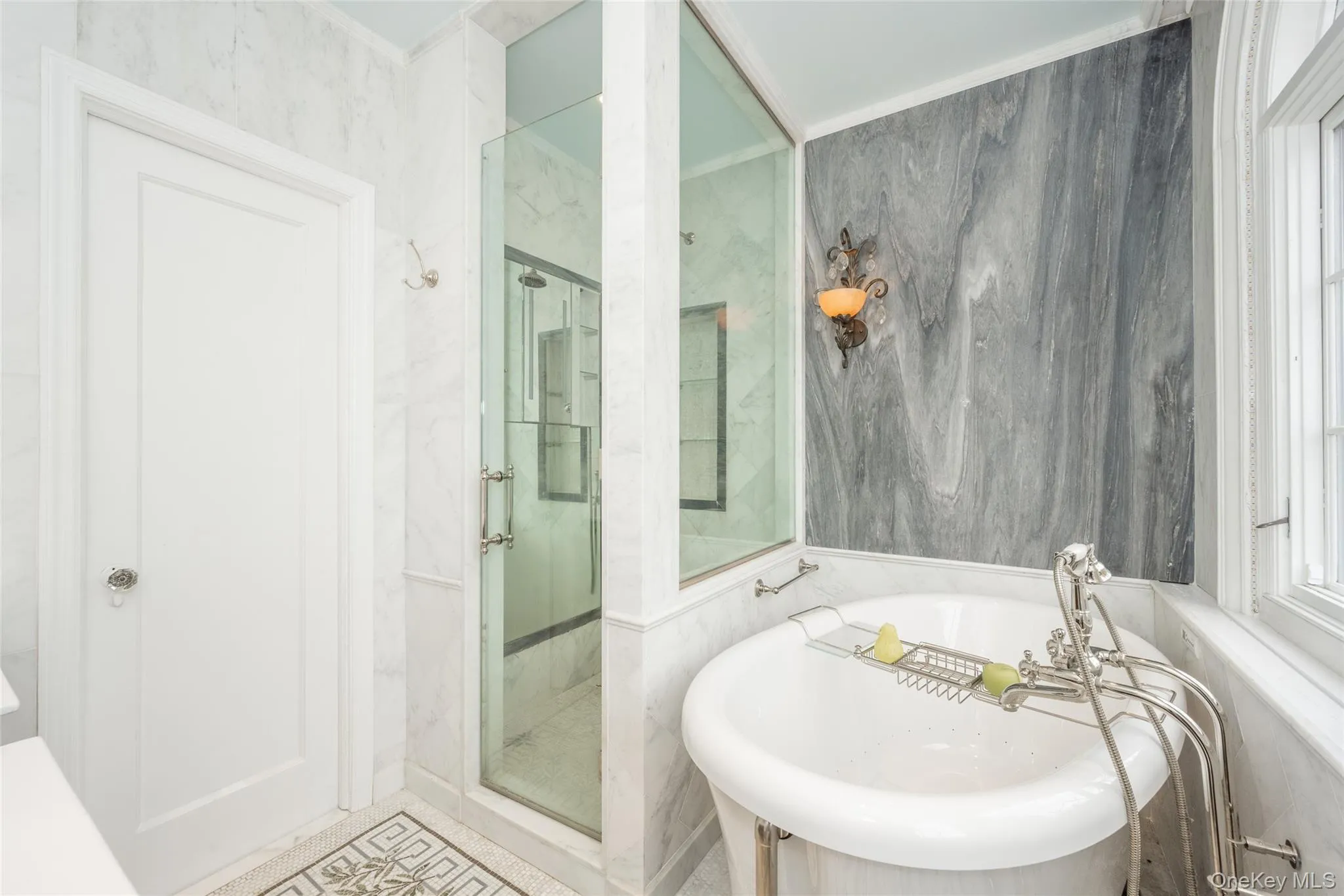 Freestanding soaking tub with a floor-mounted faucet, adjacent to a glass-enclosed shower with a rainfall showerhead Freestanding soaking tub with a floor-mounted faucet, adjacent to a glass-enclosed shower with a rainfall showerhead