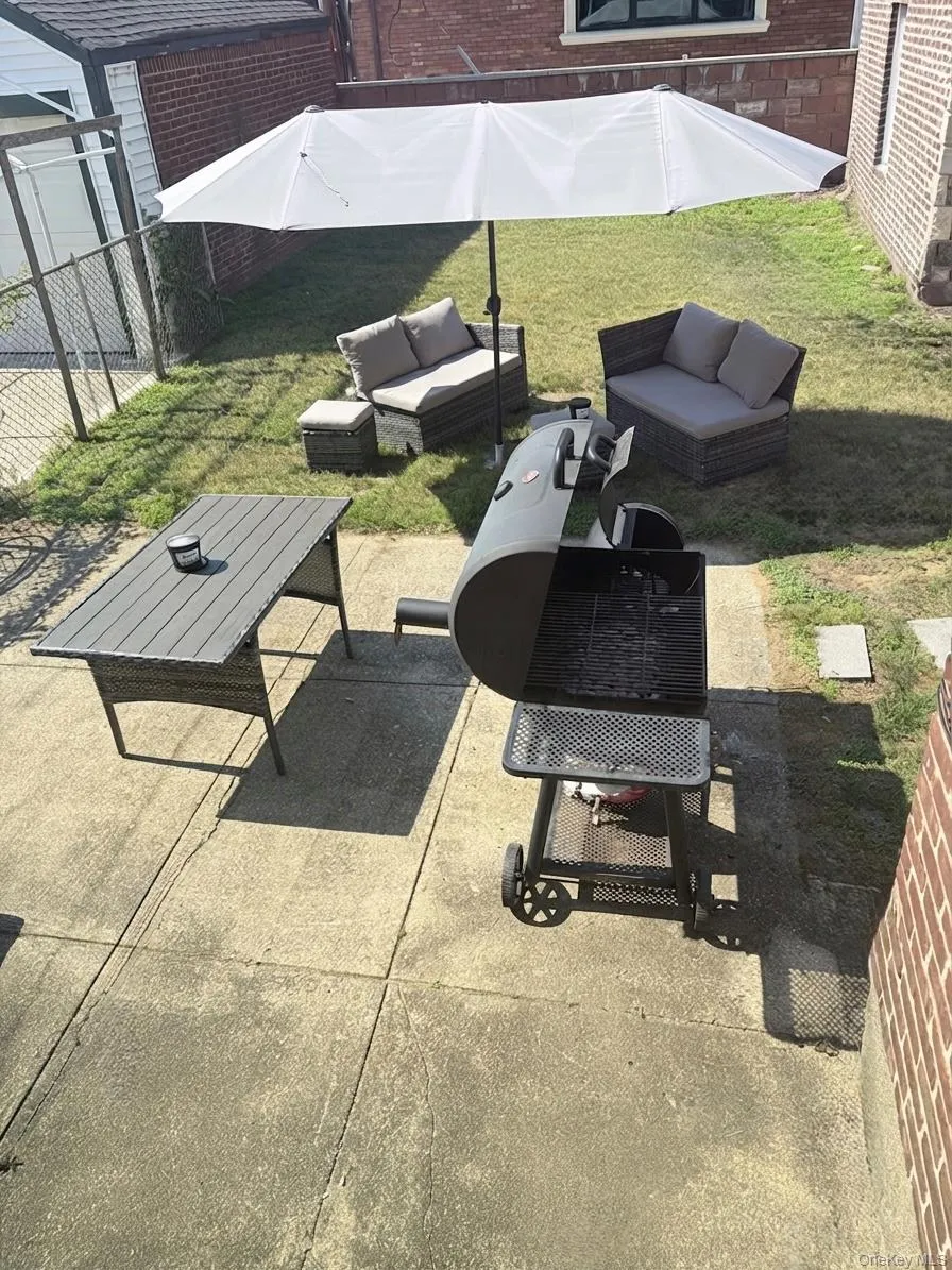 Rear yard featuring a concrete patio, a grass area, and partial brick exterior Rear yard featuring a concrete patio, a grass area, and partial brick exterior