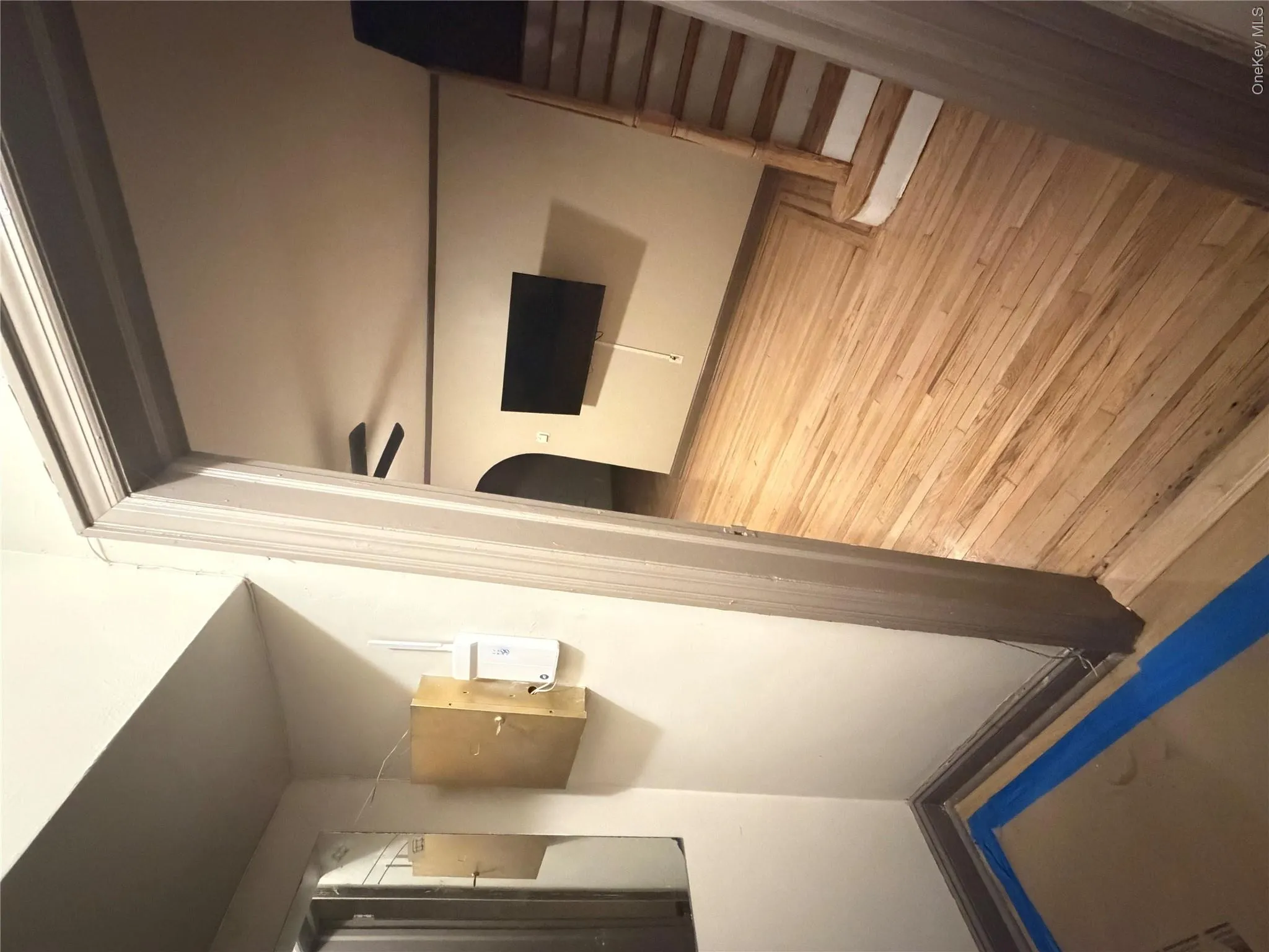 Wood-finish flooring extends throughout this interior space, featuring a staircase with painted risers Wood-finish flooring extends throughout this interior space, featuring a staircase with painted risers