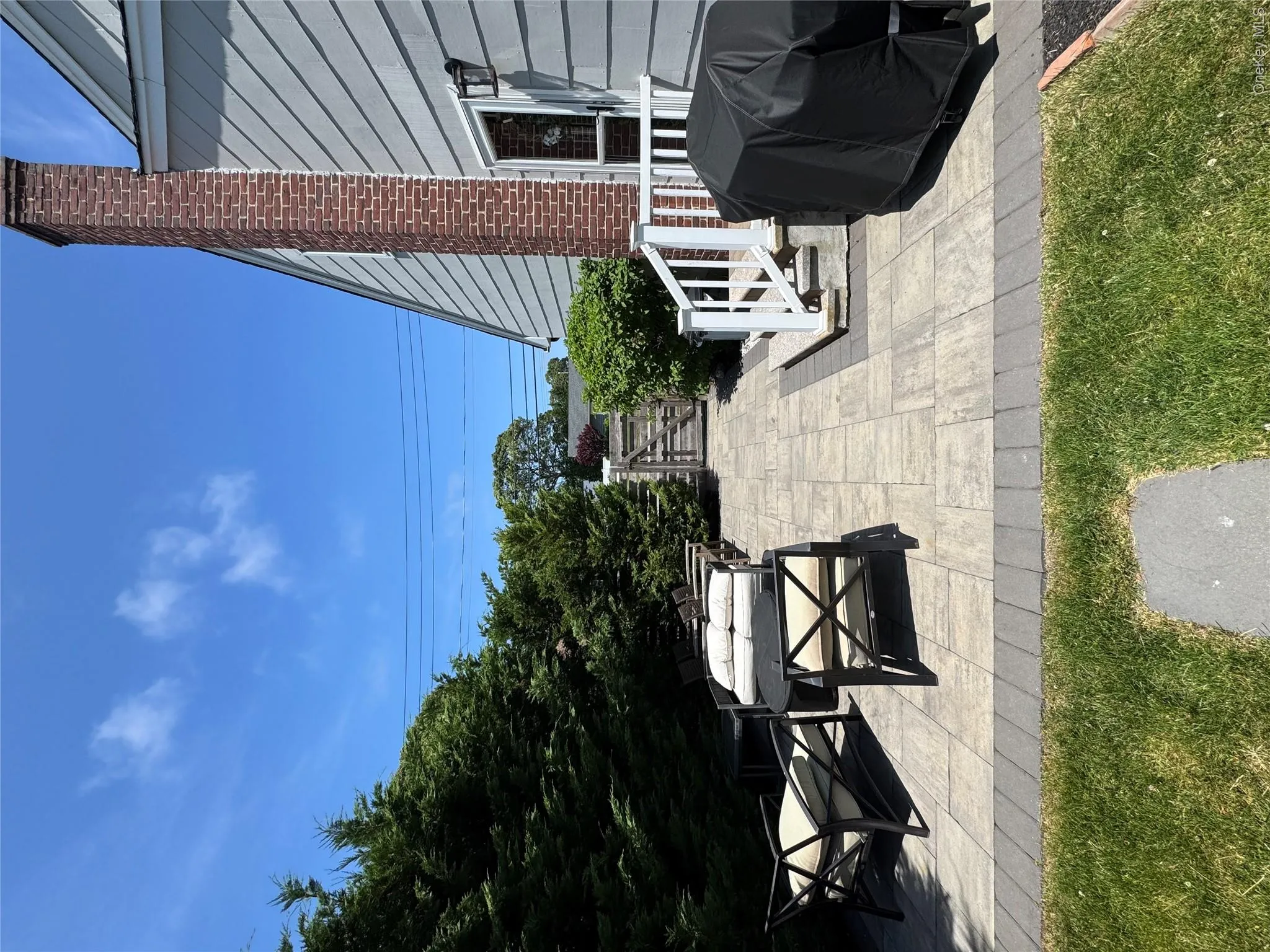 Expansive paver patio with a contrasting border, offering an integrated outdoor living area Expansive paver patio with a contrasting border, offering an integrated outdoor living area
