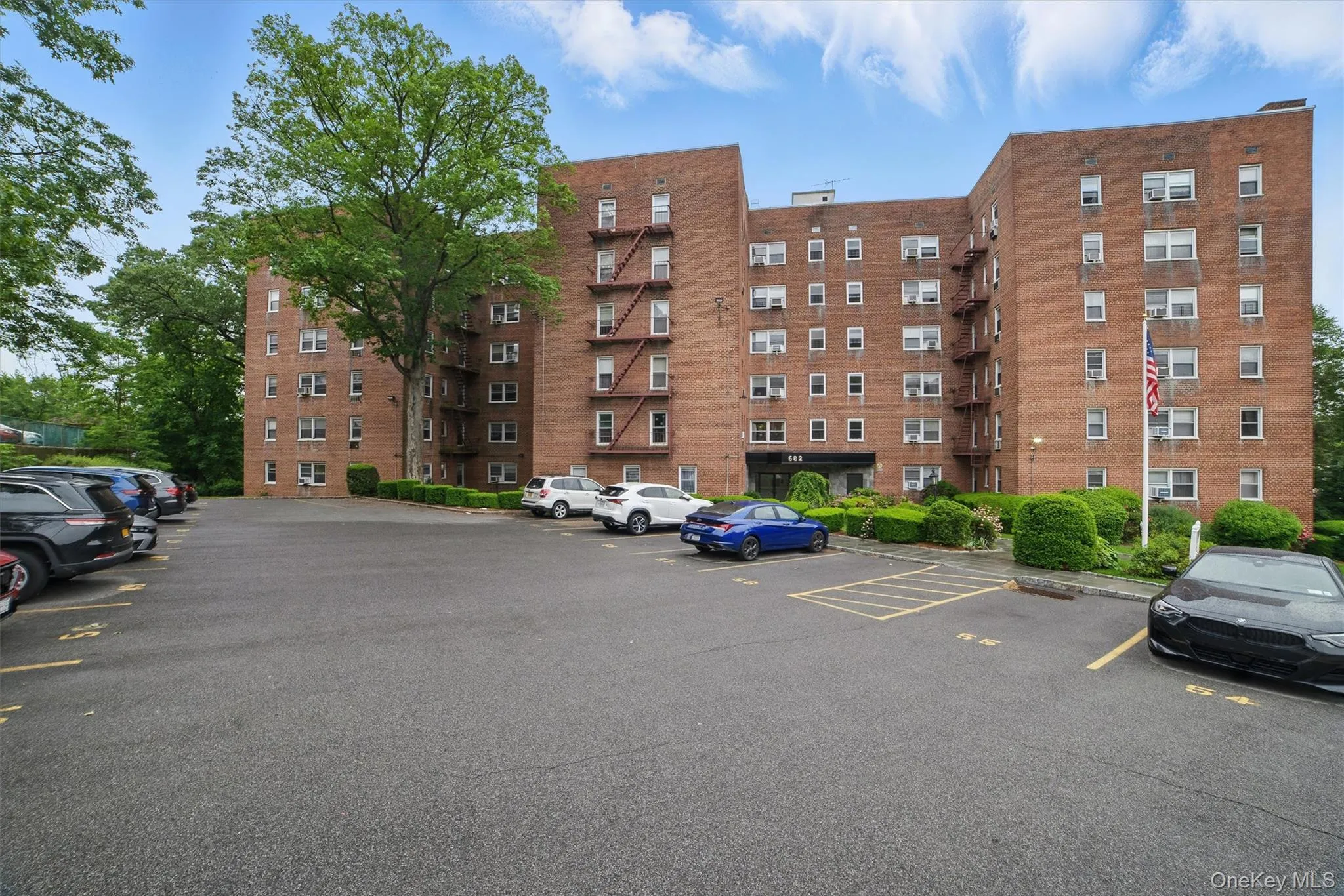View of apartment building / complex with uncovered parking View of apartment building / complex with uncovered parking