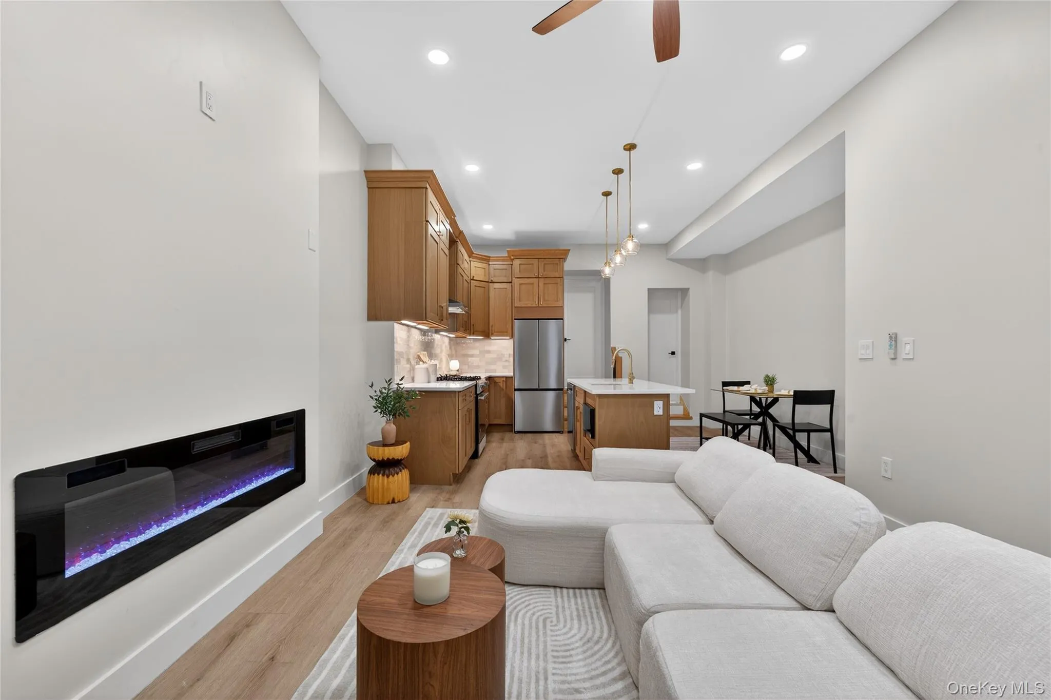 Open-concept living area with wood-finish flooring Open-concept living area with wood-finish flooring