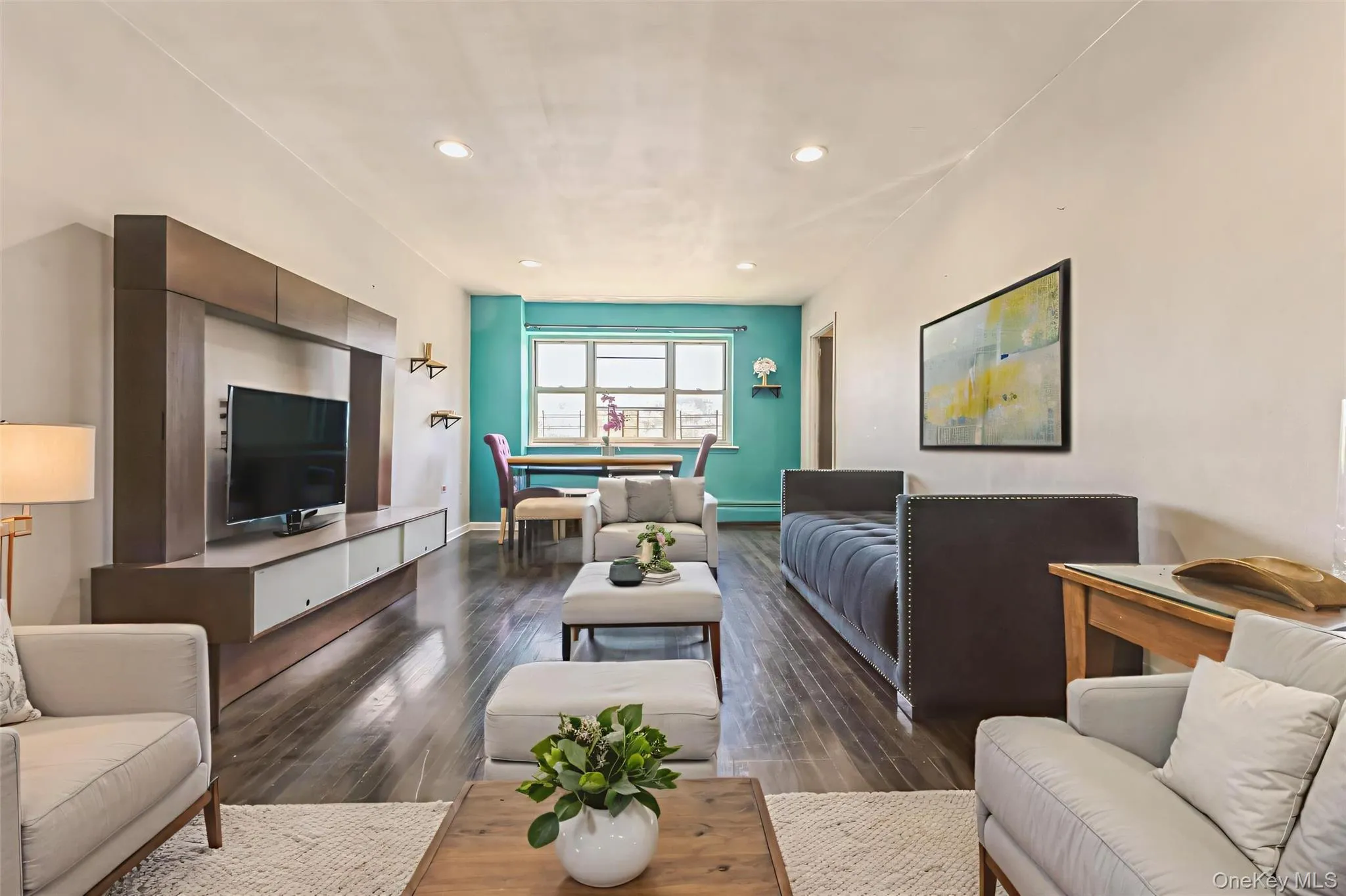 Open-concept living space featuring wood-finish flooring, recessed lighting, and a built-in media console Open-concept living space featuring wood-finish flooring, recessed lighting, and a built-in media console