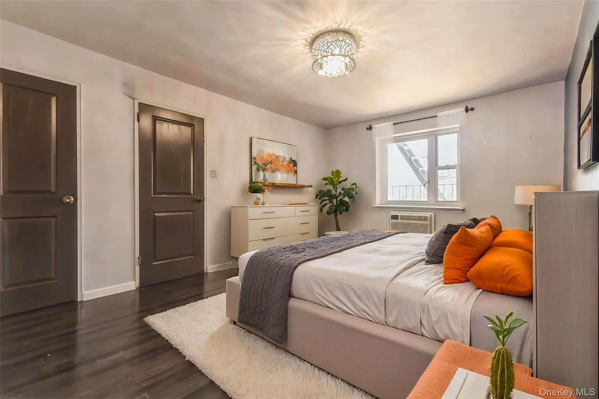 Bedroom featuring dark wood-finish flooring and two-panel interior doors Bedroom featuring dark wood-finish flooring and two-panel interior doors