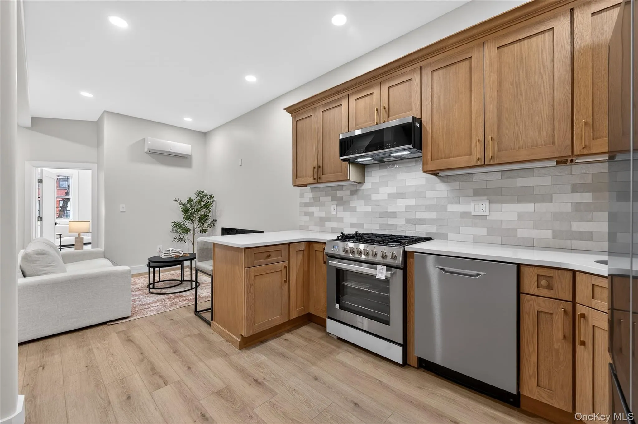 Kitchen featuring wood cabinetry, stainless steel appliances, and a light-toned subway tile backsplash Kitchen featuring wood cabinetry, stainless steel appliances, and a light-toned subway tile backsplash