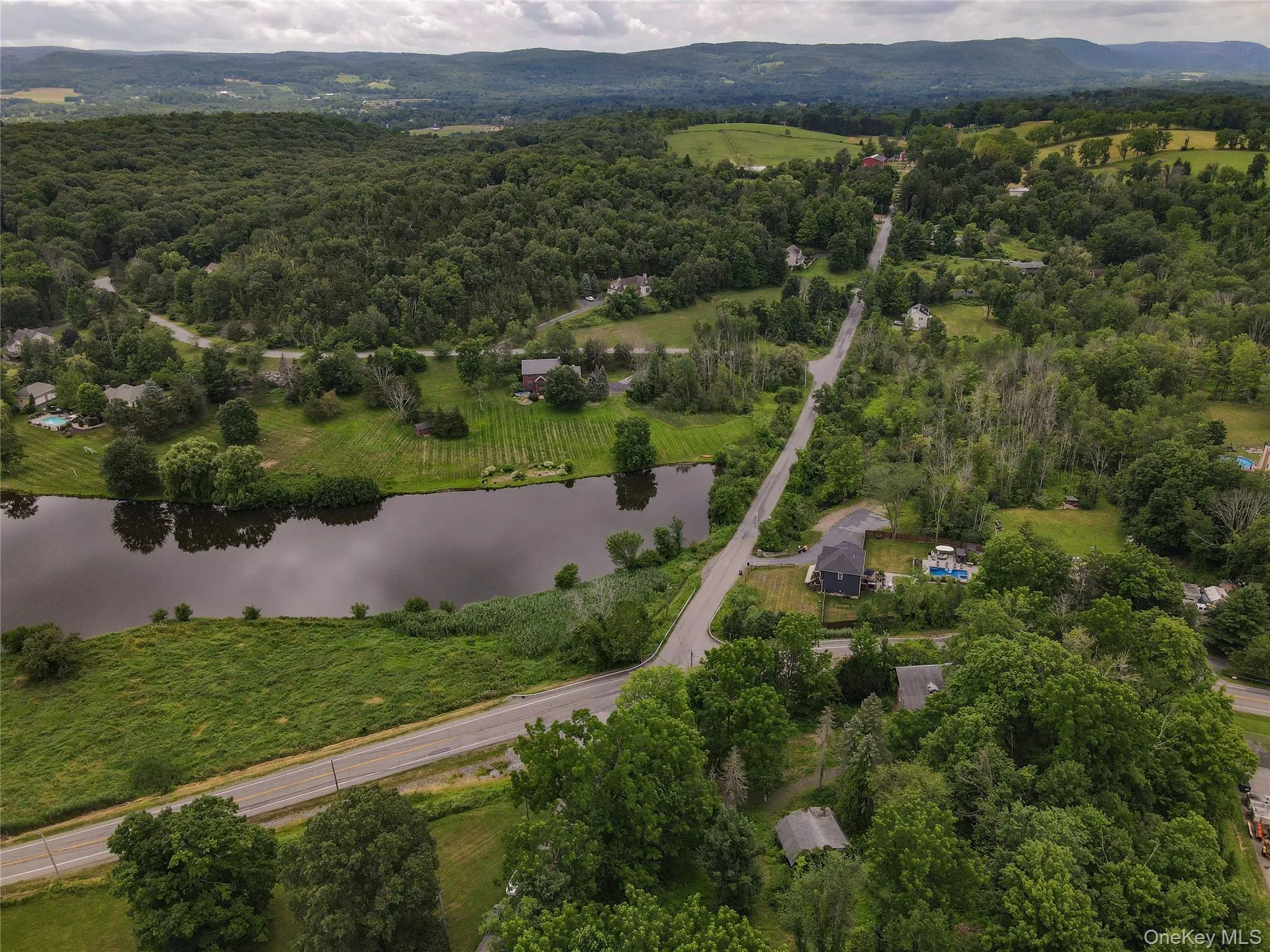 Aerial view of property's location with a water and mountain view and a forest Aerial view of property's location with a water and mountain view and a forest