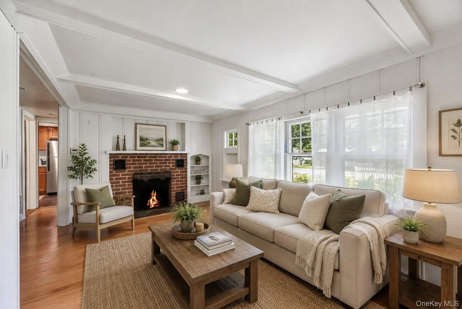 Inviting living room featuring hardwood floors, abundant natural light and a classic fireplace. Inviting living room featuring hardwood floors, abundant natural light and a classic fireplace.