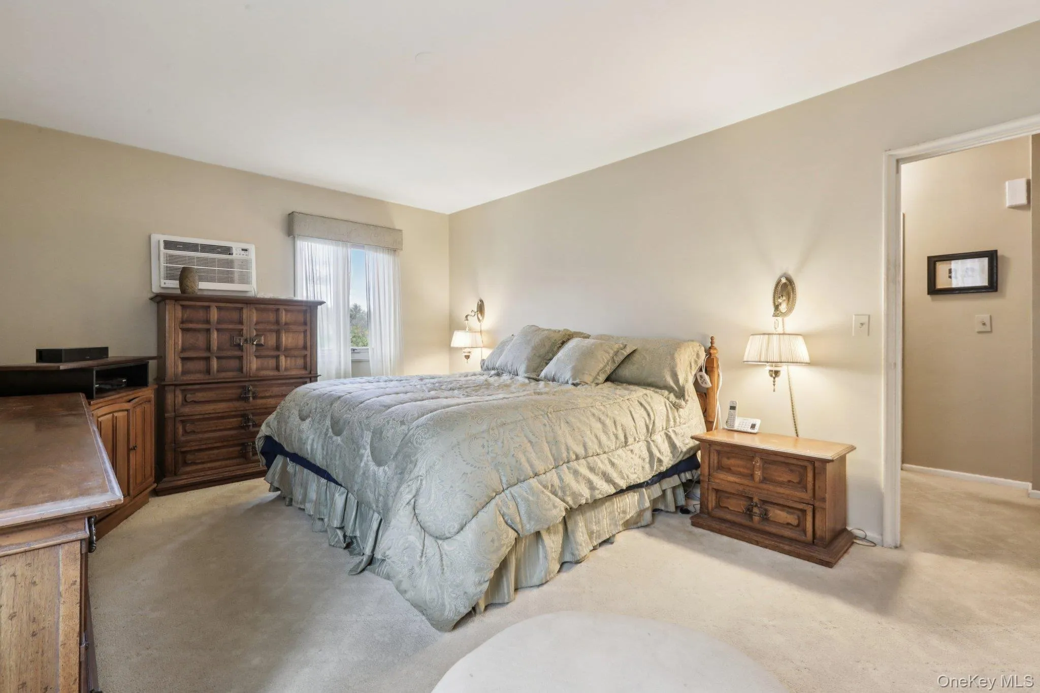 Bedroom featuring carpet floors and an AC wall unit Bedroom featuring carpet floors and an AC wall unit
