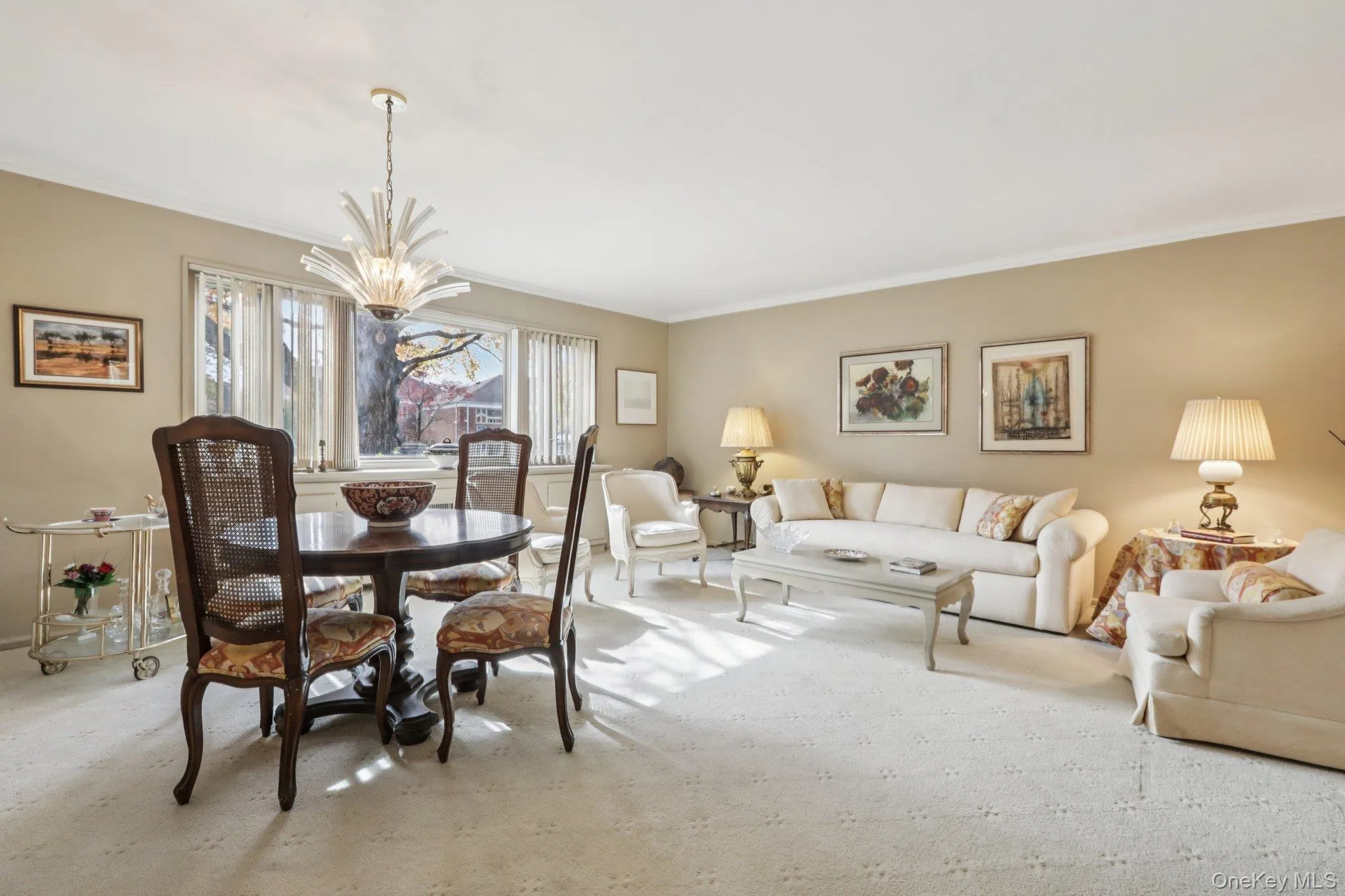 Carpeted dining space with crown molding and a chandelier Carpeted dining space with crown molding and a chandelier