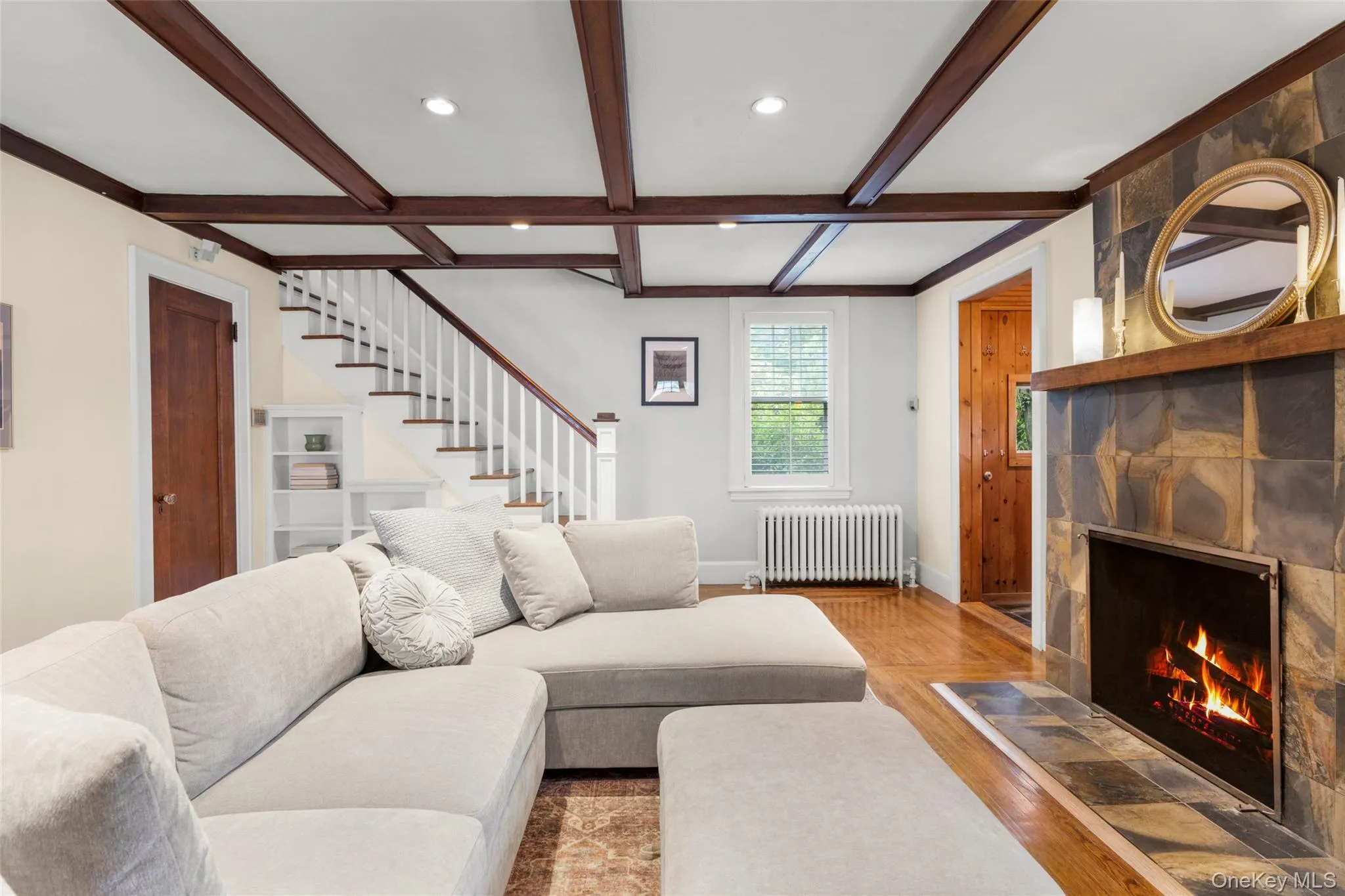 Formal living room with a wood-burning fireplace, built-in bookcase, and closet. Formal living room with a wood-burning fireplace, built-in bookcase, and closet.
