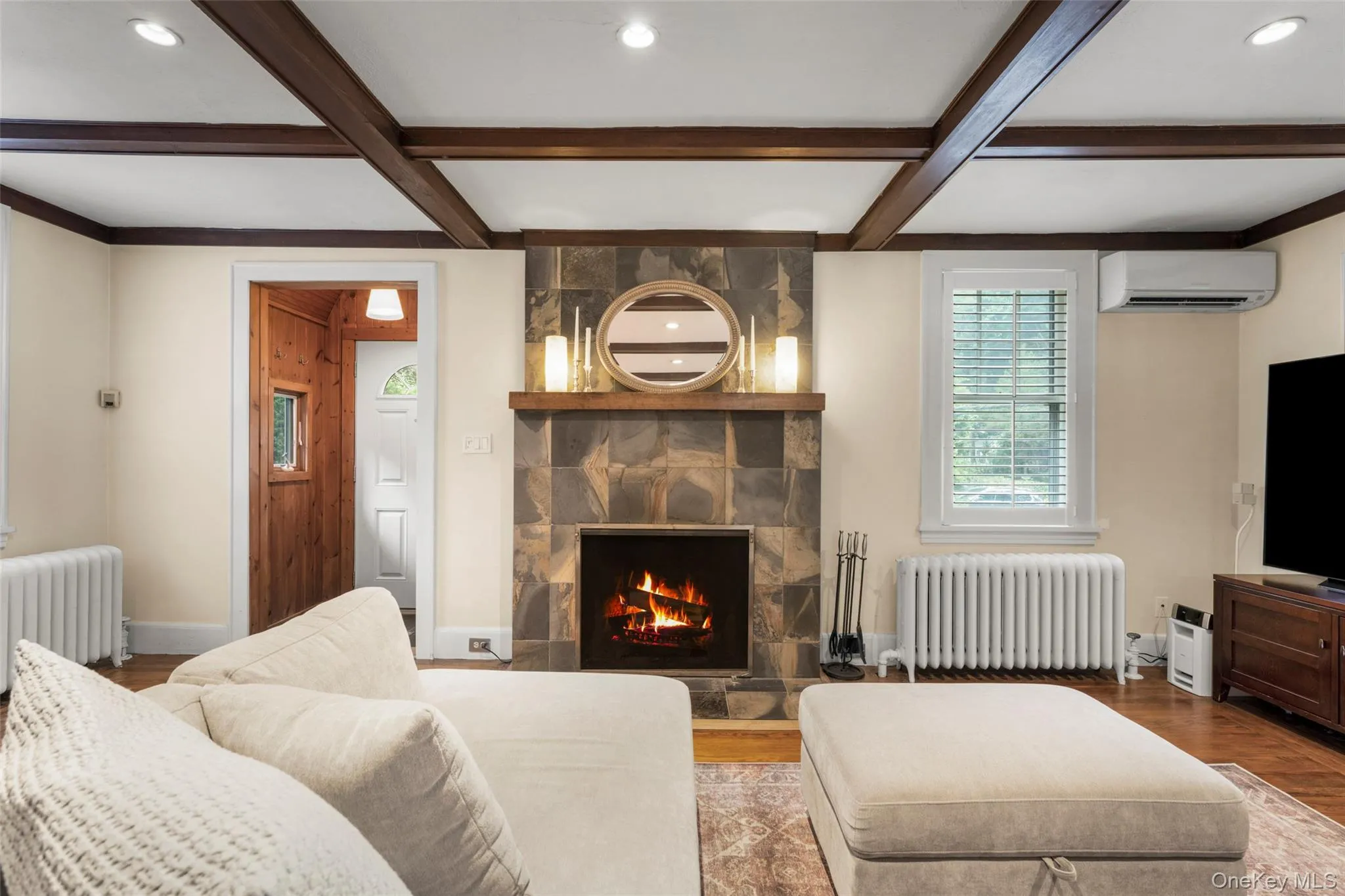 Formal living room with a wood-burning fireplace, built-in bookcase, and closet. Formal living room with a wood-burning fireplace, built-in bookcase, and closet.