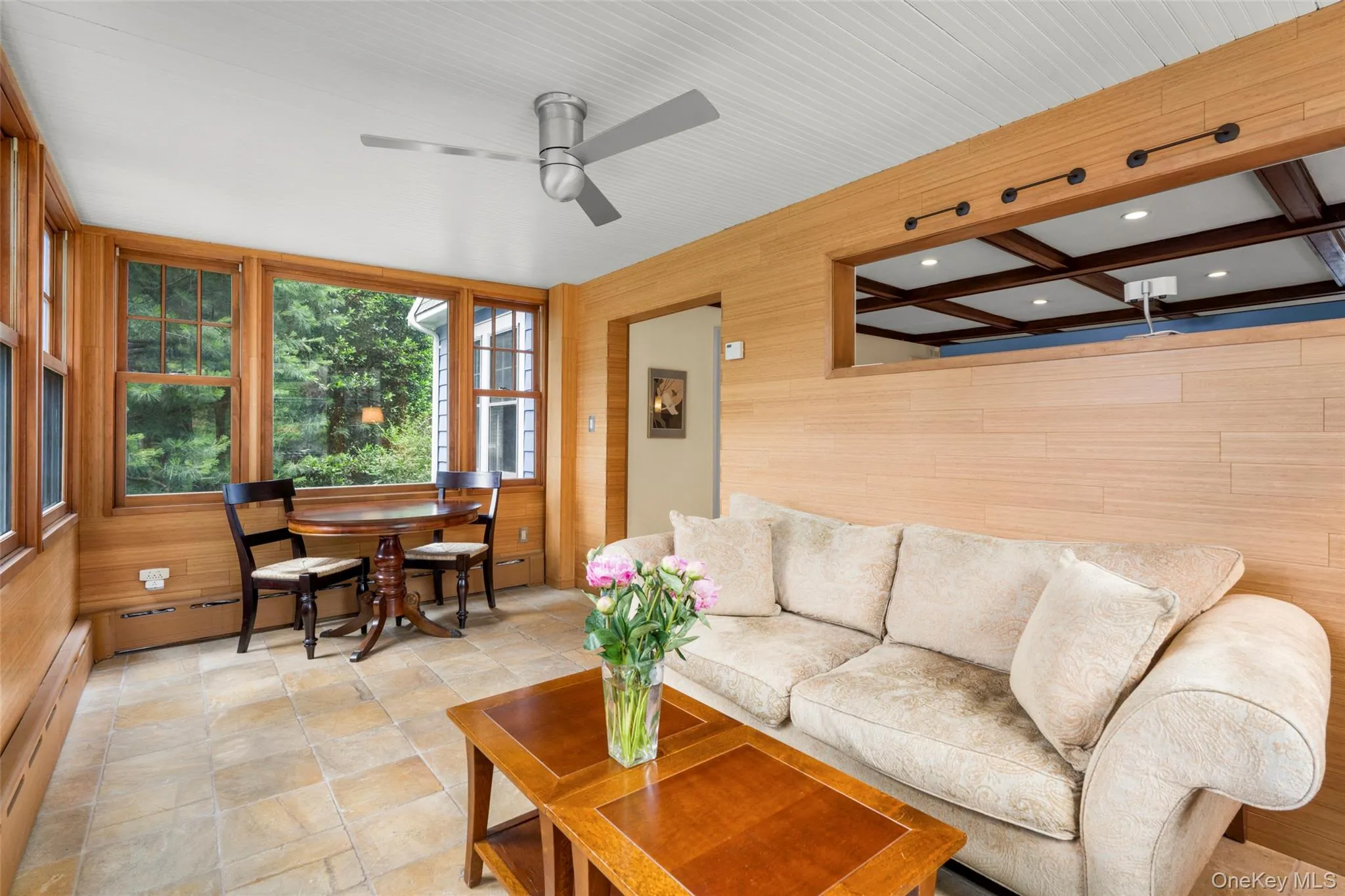 A sun-filled family room with a wall of windows. A sun-filled family room with a wall of windows.