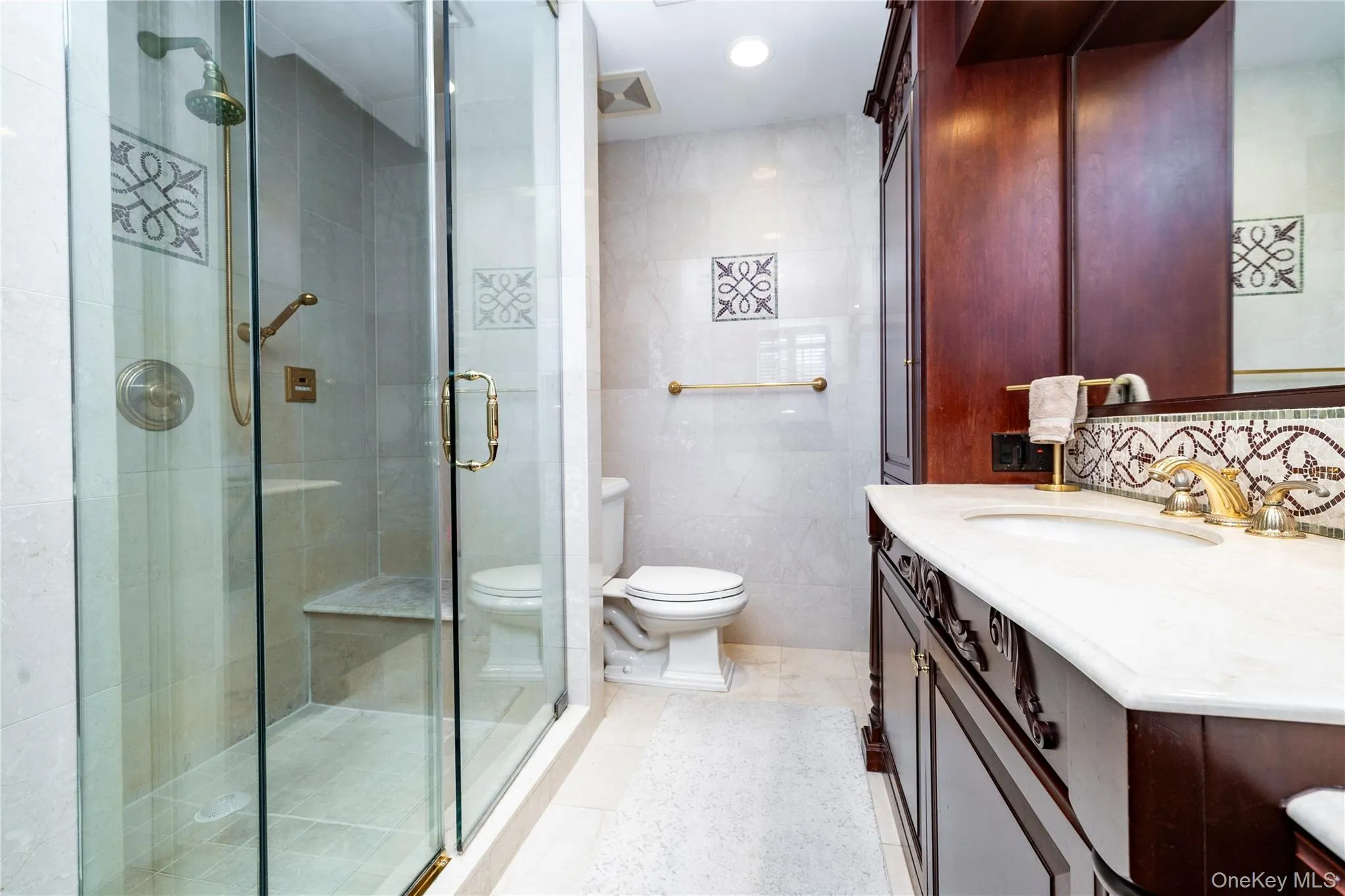 Walk-in shower with clear glass enclosure and integrated bench seating Walk-in shower with clear glass enclosure and integrated bench seating