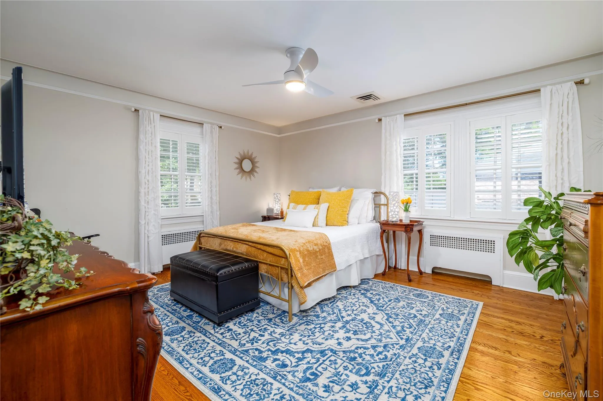 Hardwood flooring throughout featuring white plantation shutters, ceiling fan with integrated lighting, and crown molding Hardwood flooring throughout featuring white plantation shutters, ceiling fan with integrated lighting, and crown molding