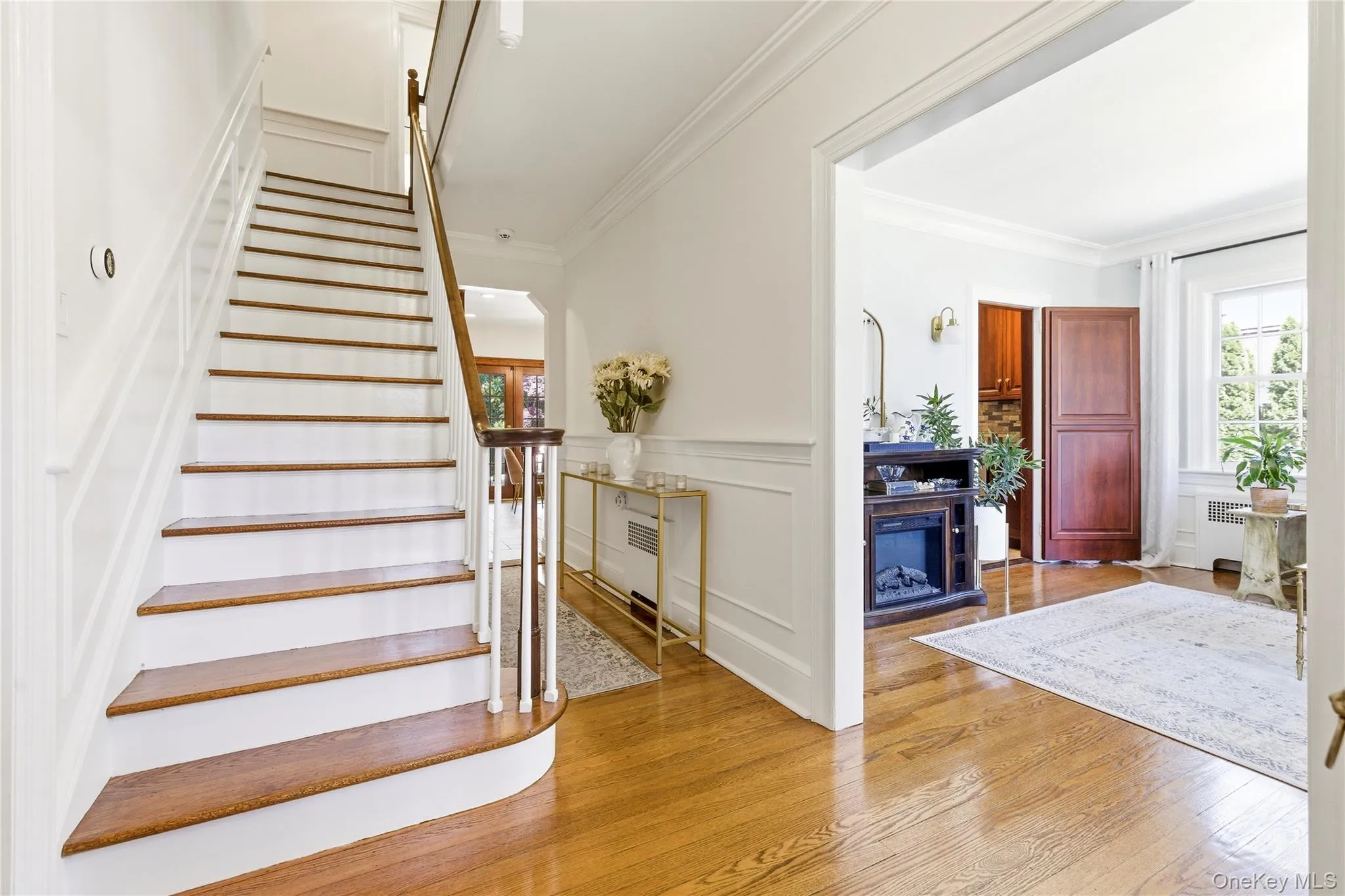 Grand staircase featuring wood-finish treads, white risers, and a wood-finish handrail Grand staircase featuring wood-finish treads, white risers, and a wood-finish handrail